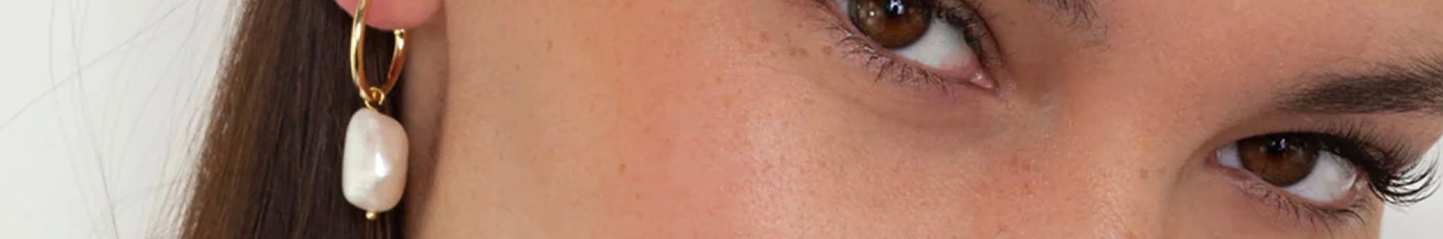 Bianc pearl drop earring close-up on model with gold hoop and freshwater pearl, clean lines and contemporary jewellery design