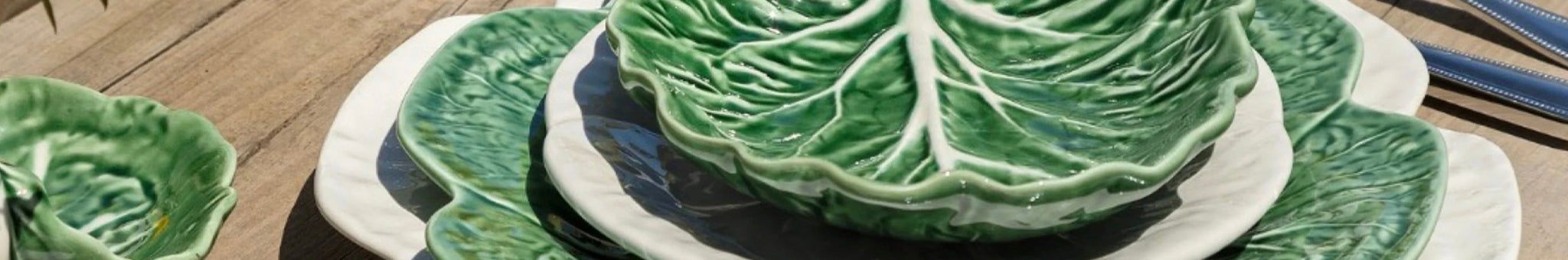 Bordallo Pinheiro glazed ceramic cabbage leaf plates and platter on table, Portuguese Caldas da Rainha pottery