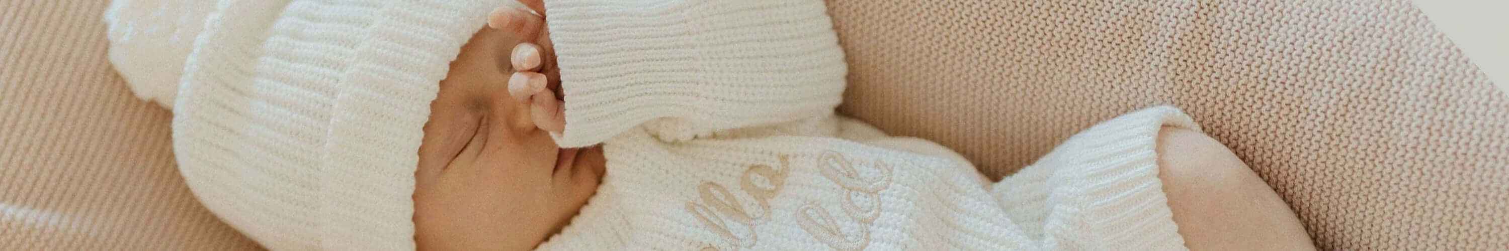 A close-up of a sleeping baby in a cozy white outfit from Confetti Kidz, showcasing softness and comfort.
