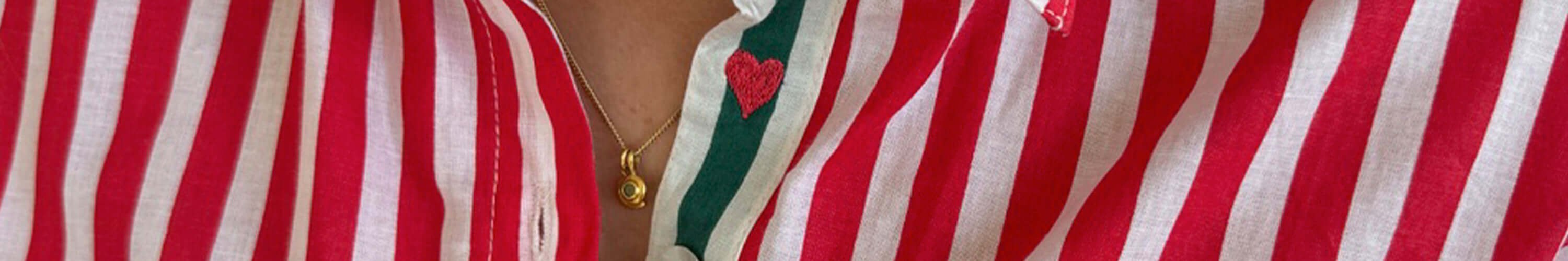 Close-up of a red and white striped shirt with a heart embroidery and a gold necklace from Art in My Wardrobe.