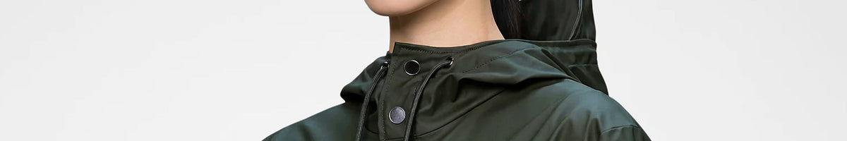 Rains dark green waterproof jacket with hood up, side view brand banner