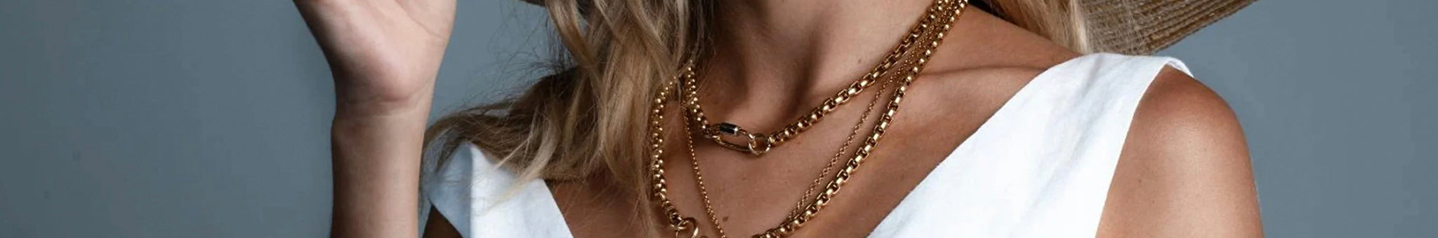 Cathy Pope limited edition New Zealand jewellery, bold timeless gold chain necklaces layered on woman in white dress
