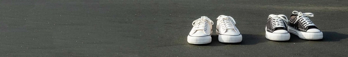 Collective Canvas minimalist sustainable everyday sneakers in clean white and black low-top canvas design on pavement