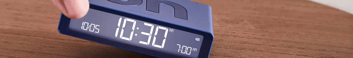Lexon digital alarm clock with LED display showing 10:30 on a wooden surface