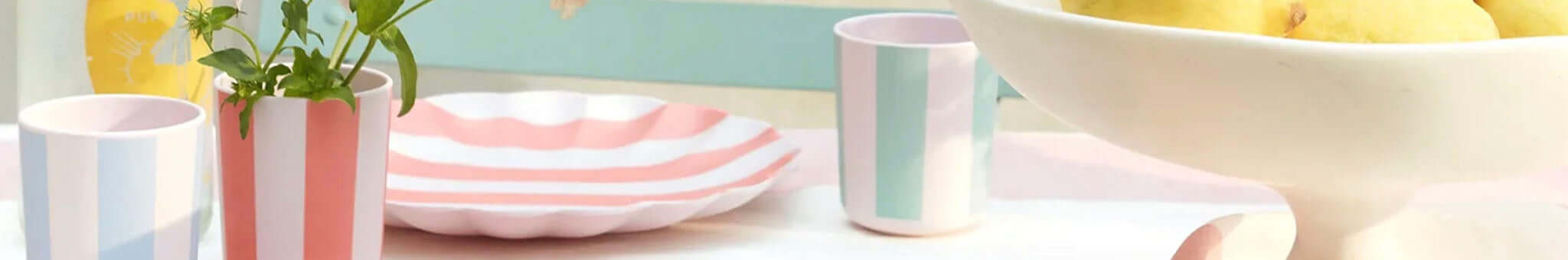 Meri Meri party table scene with pastel striped cups, pink plate, and summer decor for celebrations