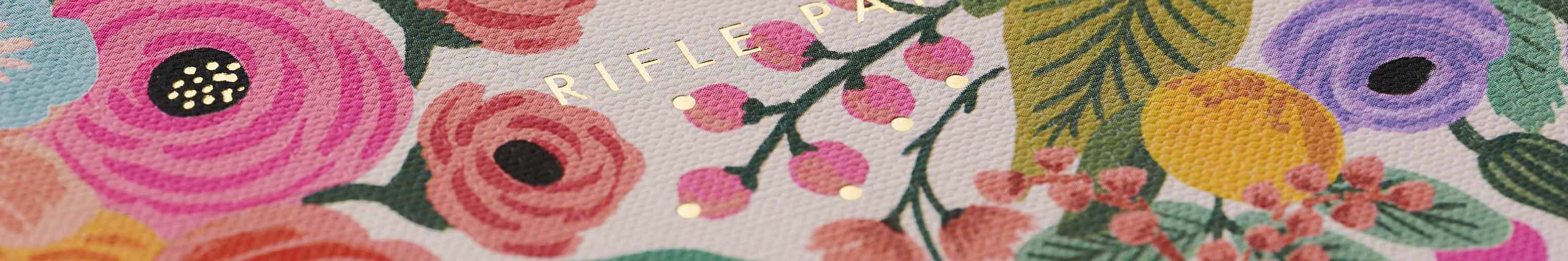 Rifle Paper cherry market list notepad with floral border and matching stationery on desk