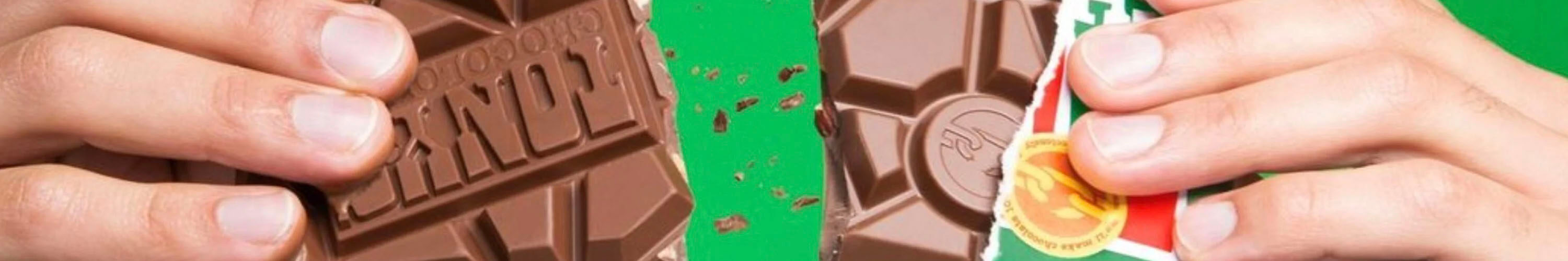 Tony's Chocolonely chocolate bar close-up being broken by hands, fair trade Dutch chocolatier with colorful packaging