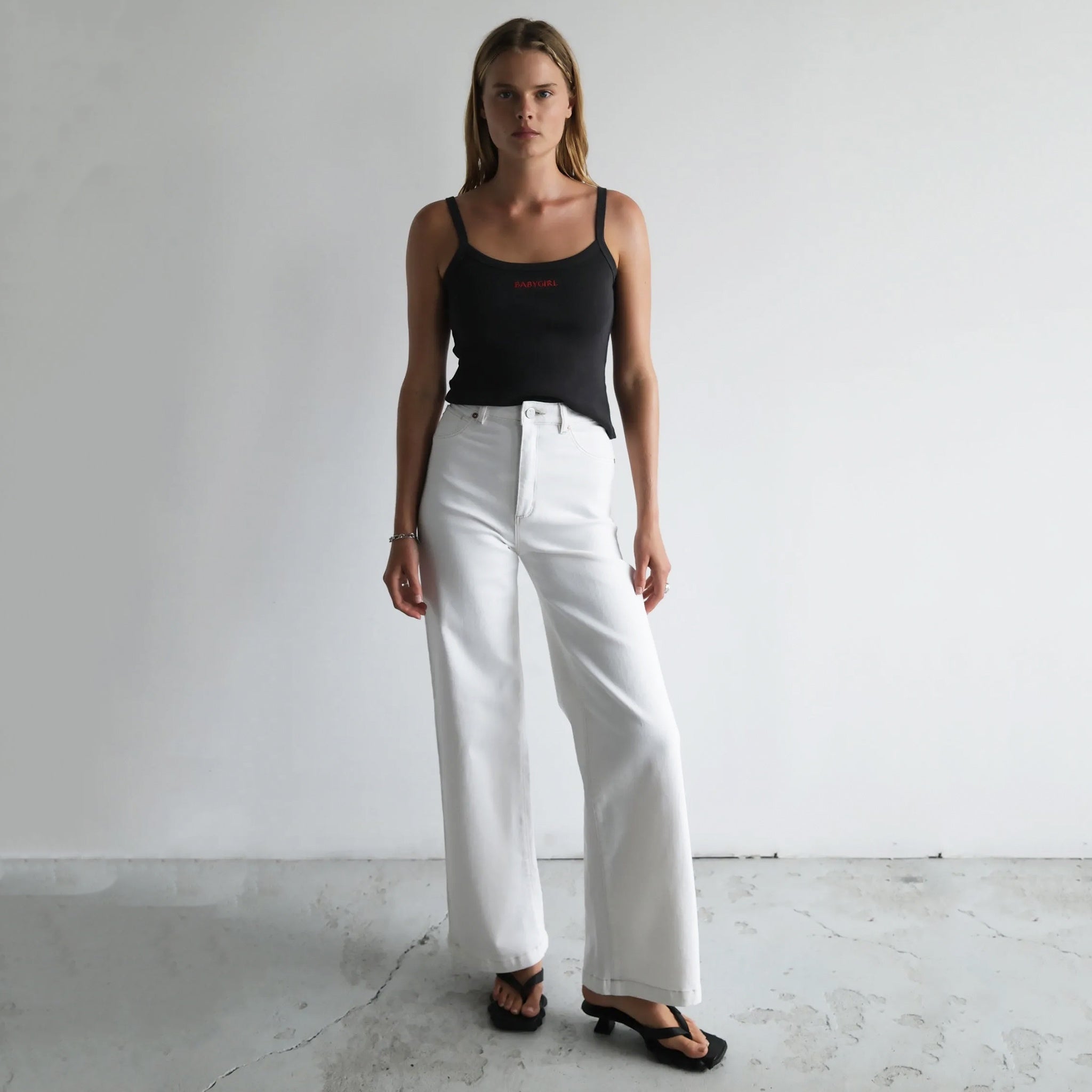 Woman wearing a pair of Abrand 94 High & Wide Jeans in Western White.