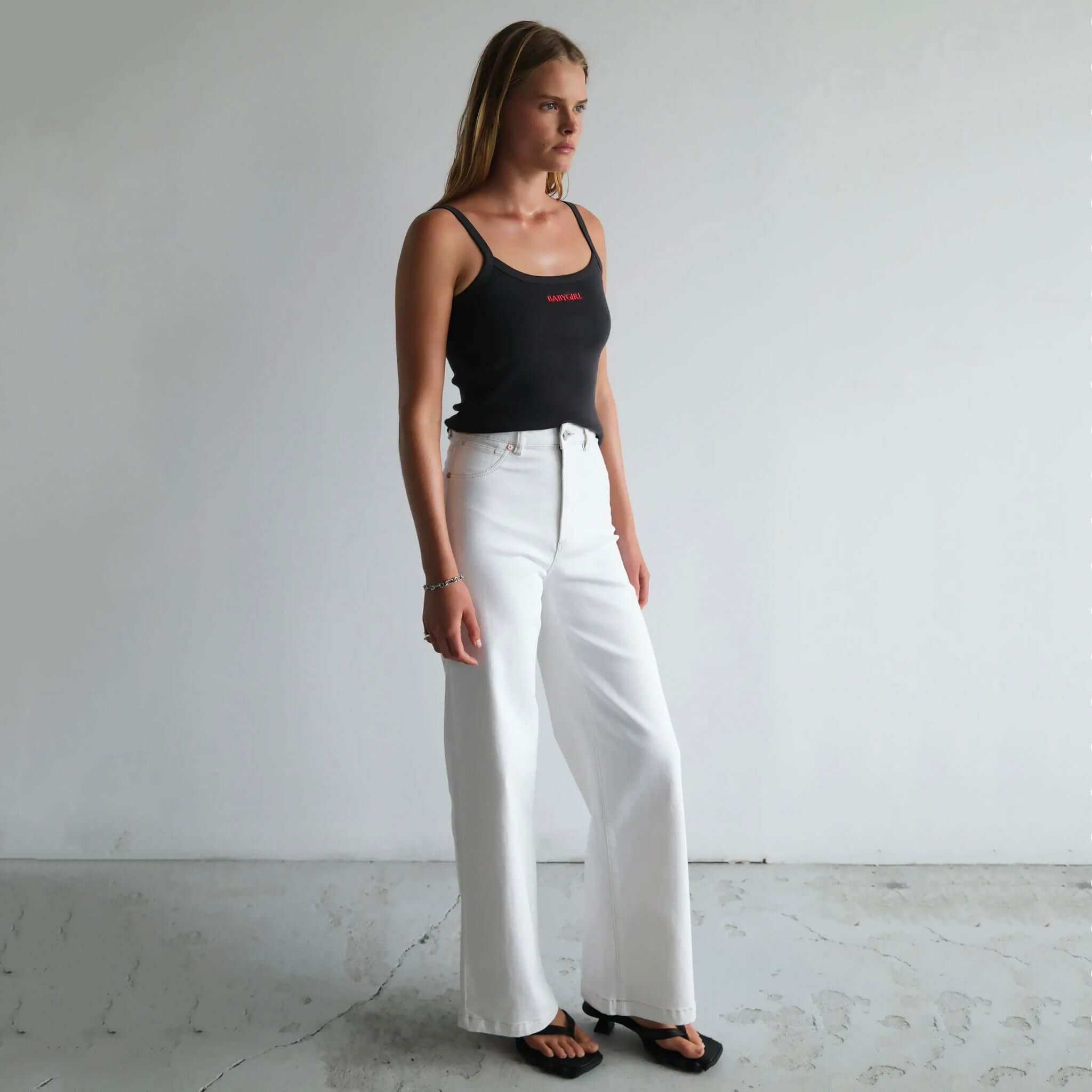 Woman wearing a pair of Abrand 94 High & Wide Jeans in Western White.