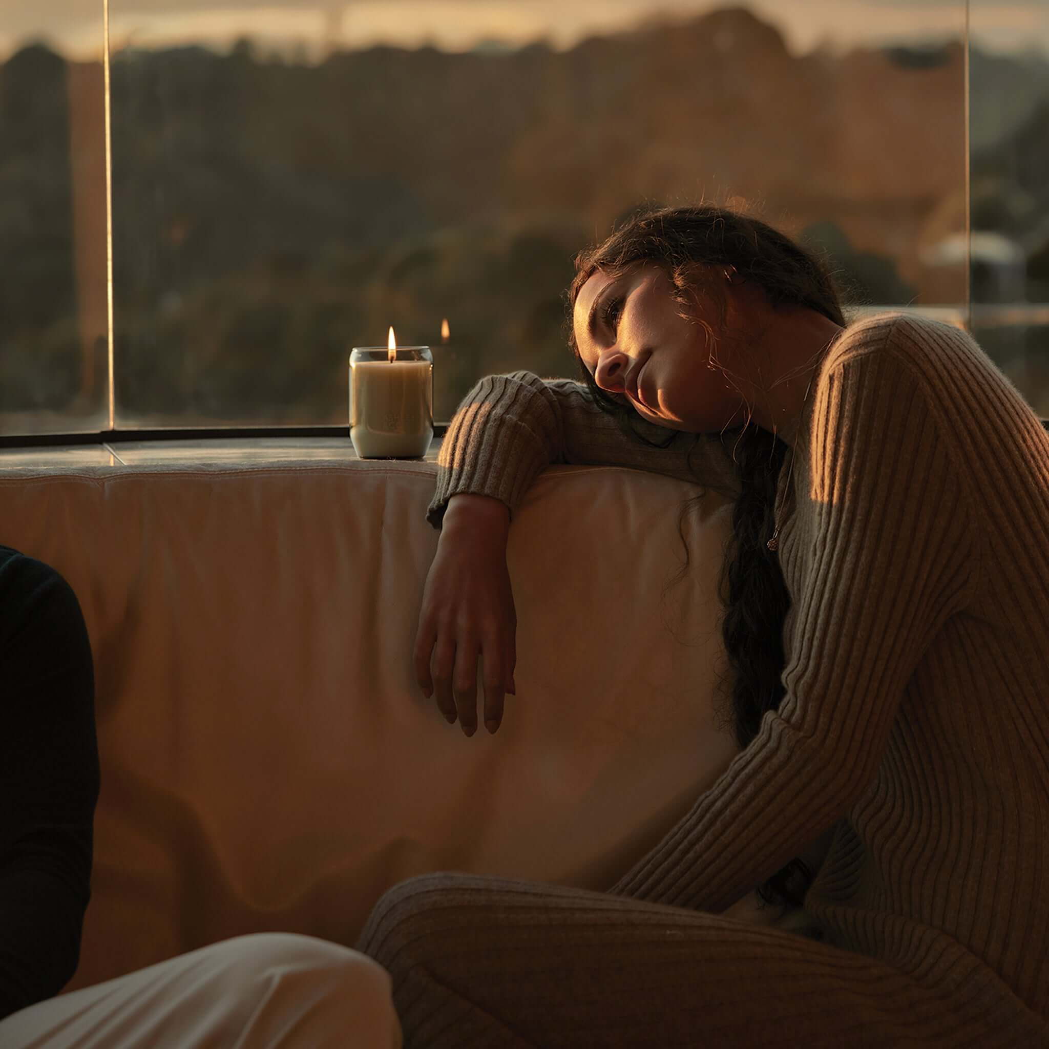 Ashley & Co Waxed Perfume Candle lit on sofa by window at sunset, natural wax handmade New Zealand, cozy home fragrance