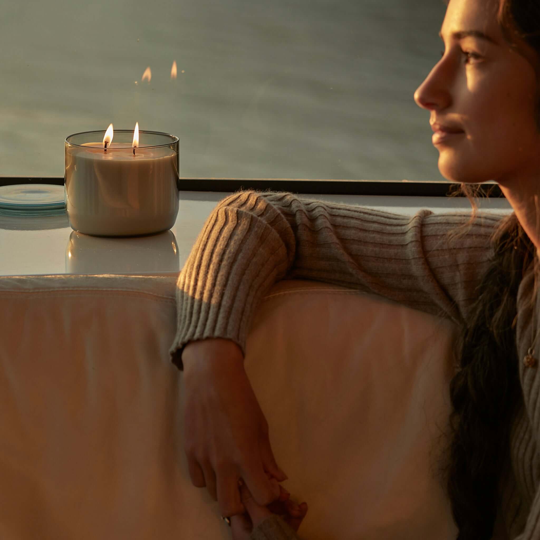 Alt Tag: Ashley & Co Waxed Perfume XL Candle lit in hand-blown glass jar with lid, double-wicked natural wax on windowsill at sunset