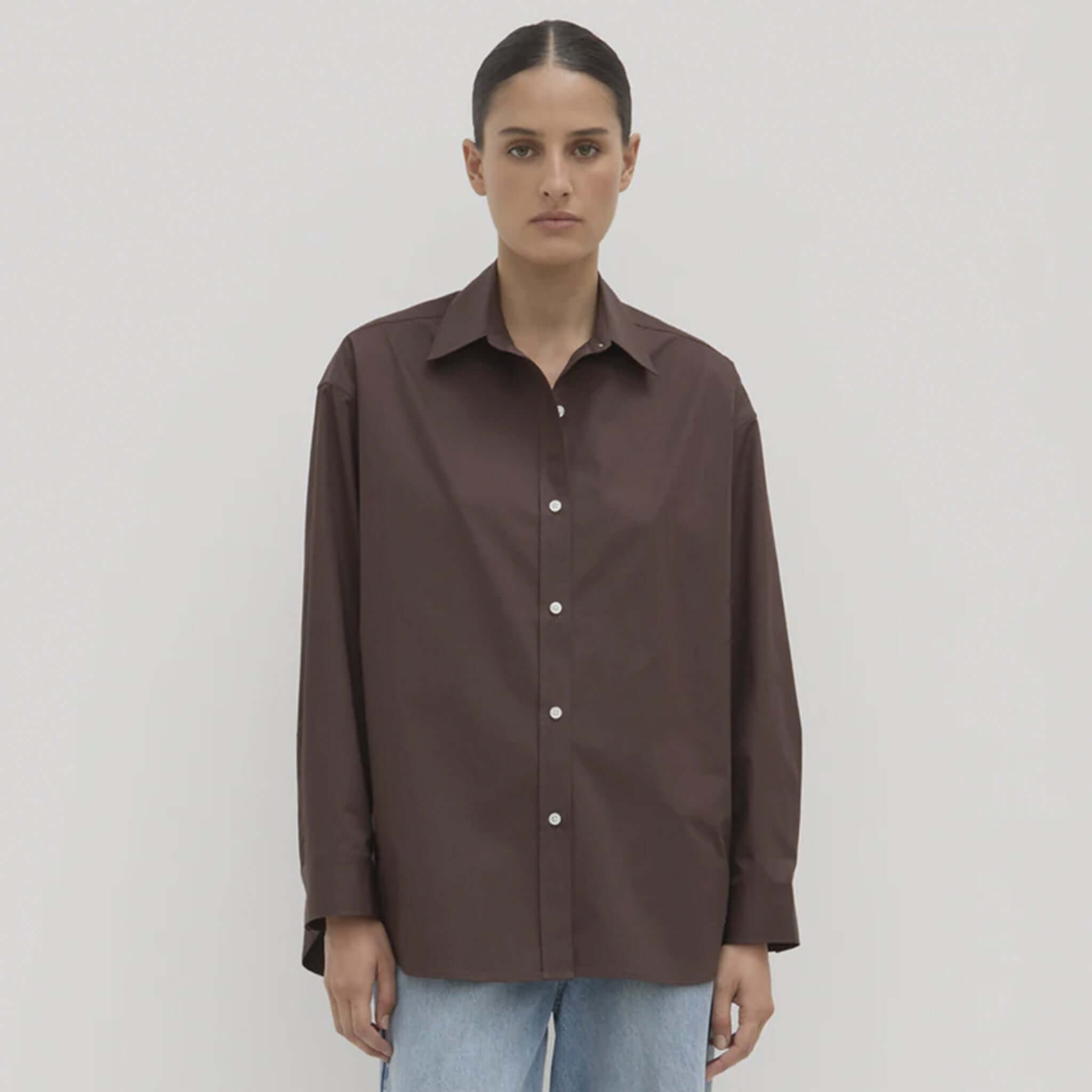 Person wearing a brown shirt on a plain background