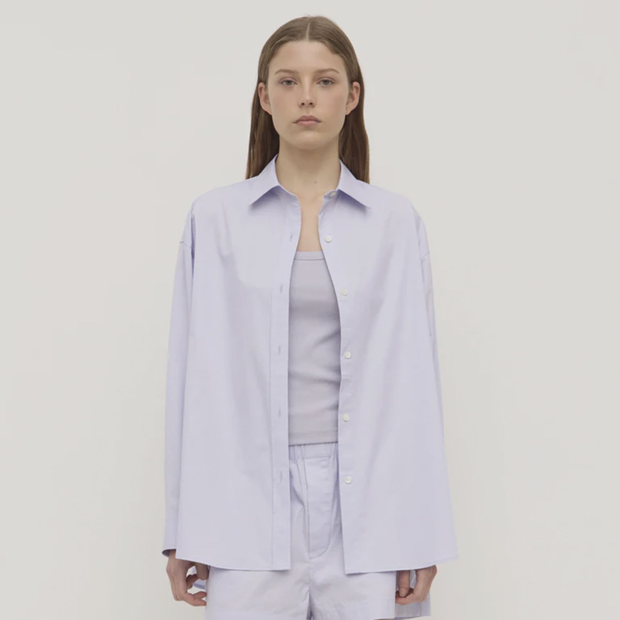 Person wearing a light purple shirt and pants on a plain background