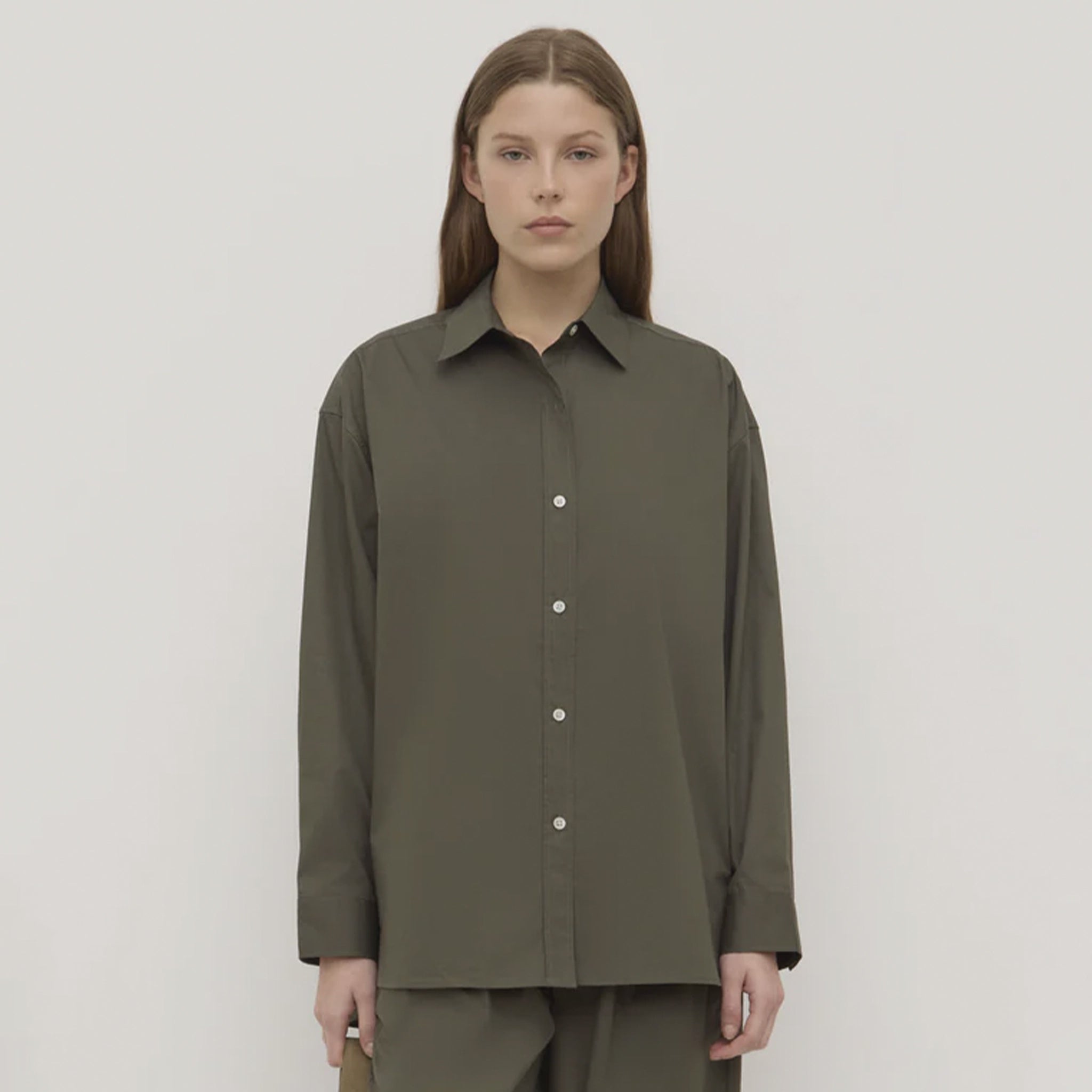 Woman wearing a green shirt with a plain background