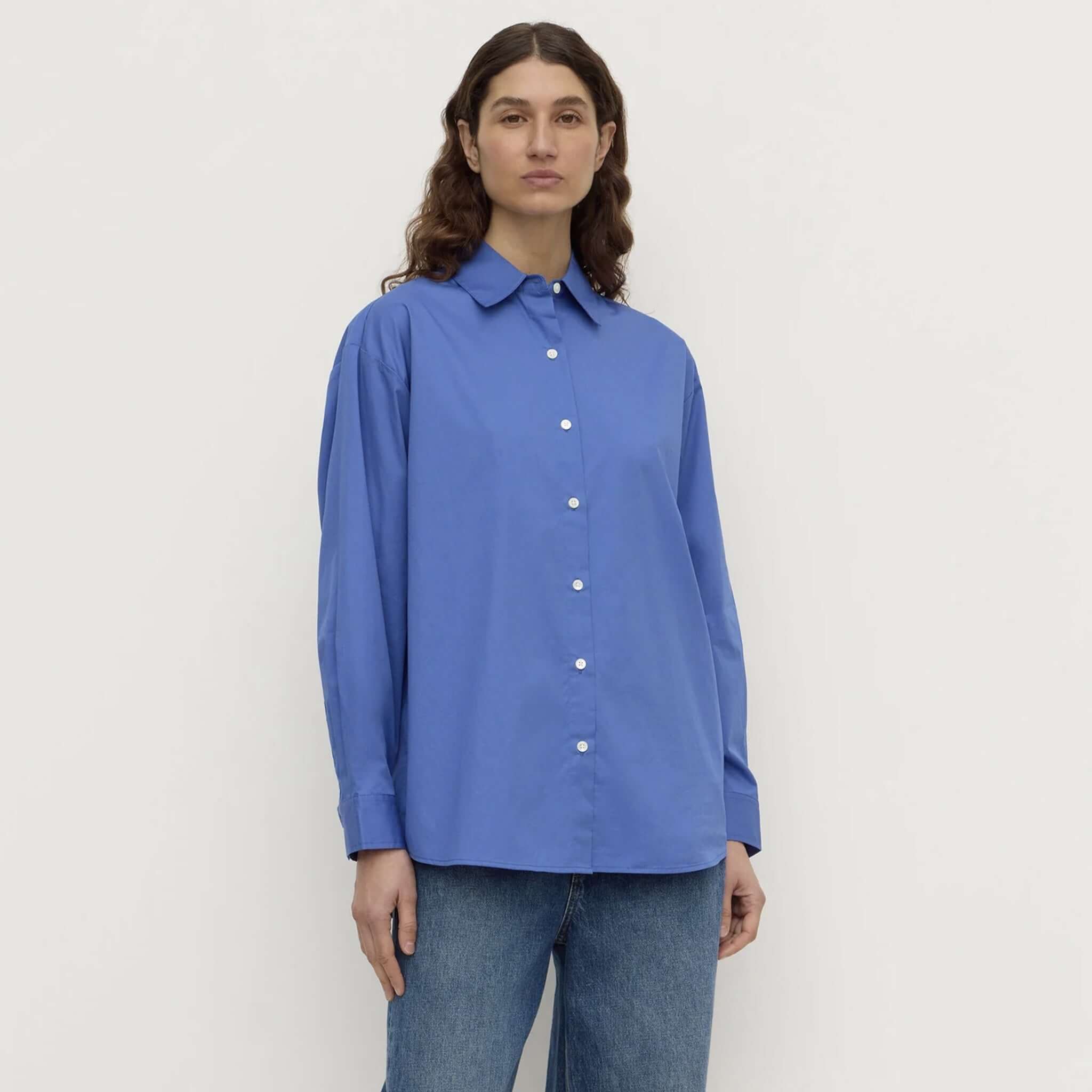 Assembly Label Micha Poplin Long Sleeve Shirt - New Blue worn by a model, featuring a classic collar and mother of pearl buttons.
