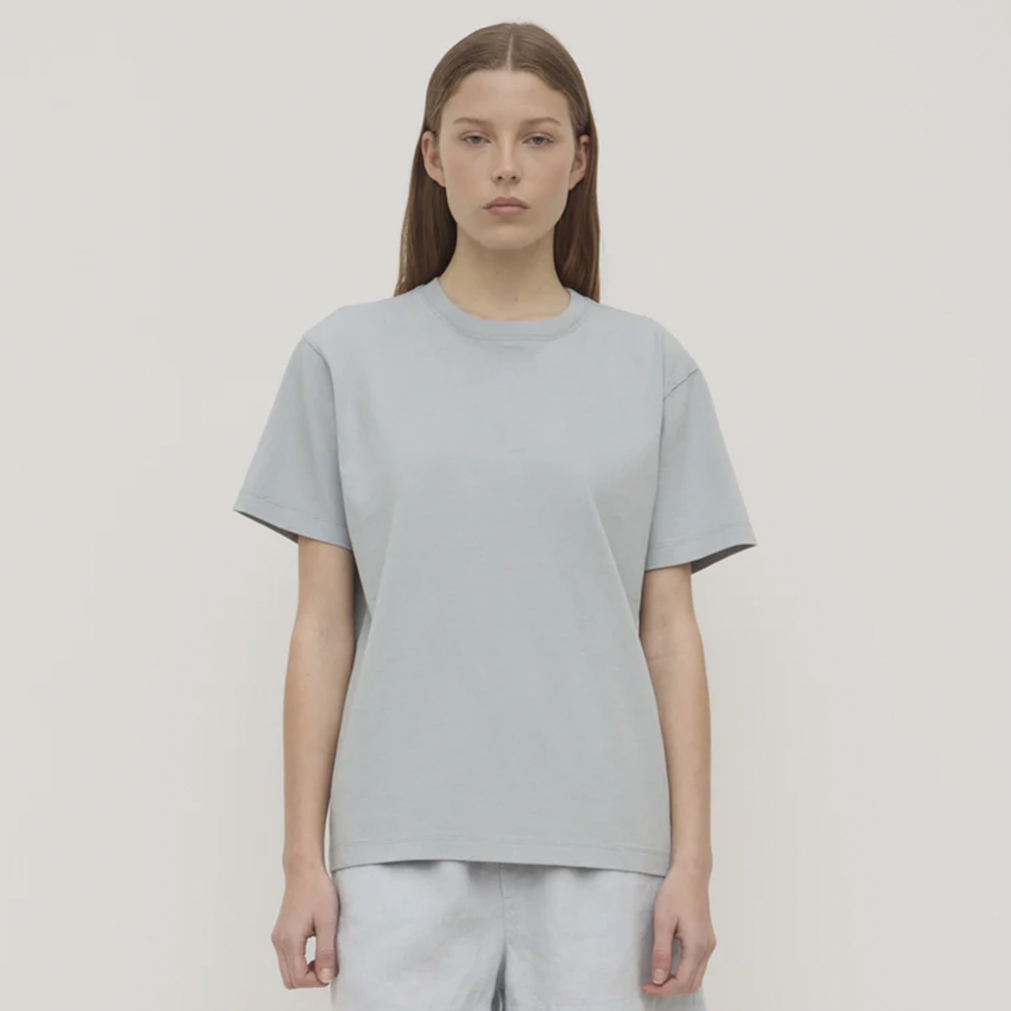 Person wearing a light blue t-shirt and pants on a plain background