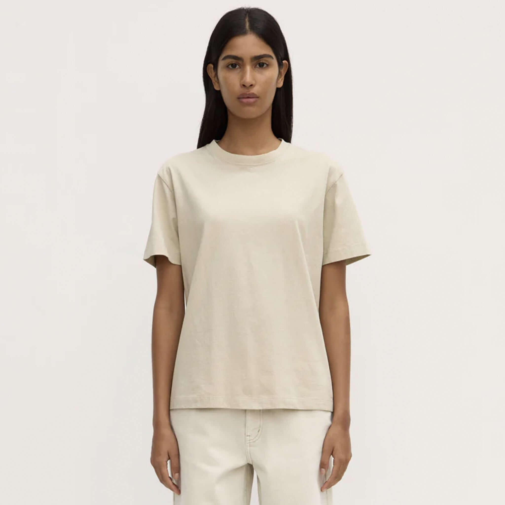 Person wearing a beige t-shirt and pants on a white background