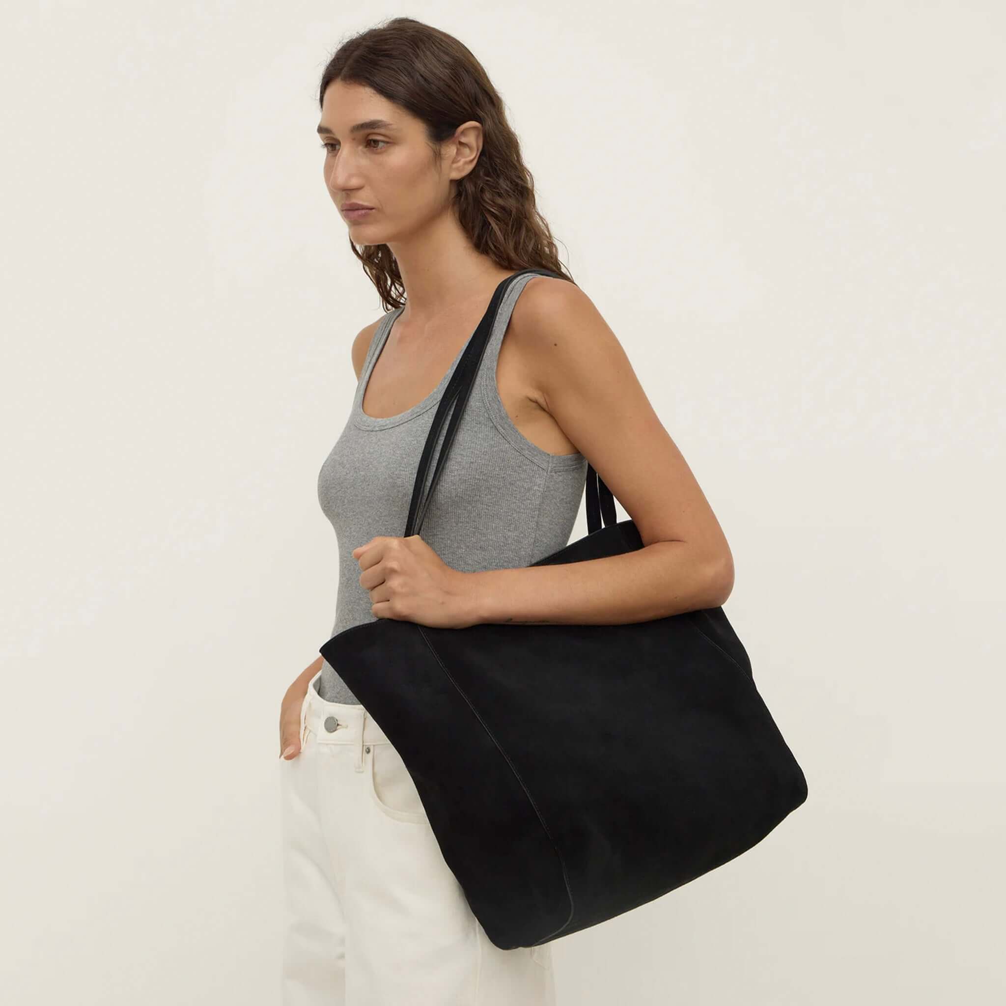 Alt Tag: Assembly Label Paige Suede Tote Bag - Black worn as relaxed shoulder tote with slim straps, spacious unstructured suede carry-all