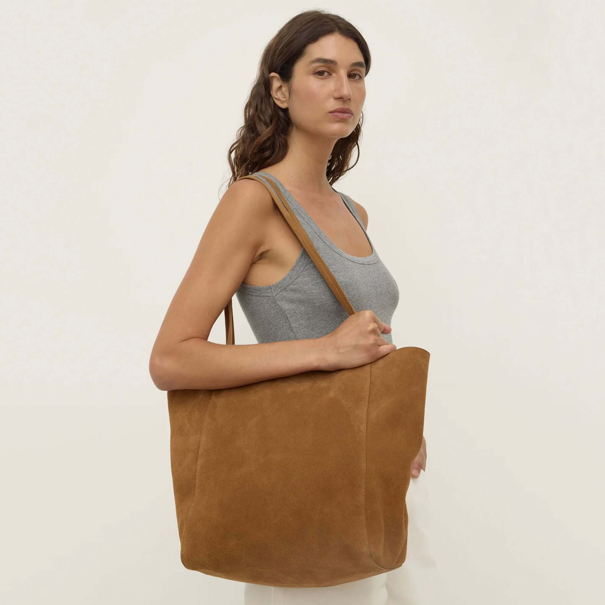 Alt Tag: Assembly Label Paige Suede Tote Bag - Tan on model, 100% suede unstructured shoulder tote with slim straps and magnetic closure
