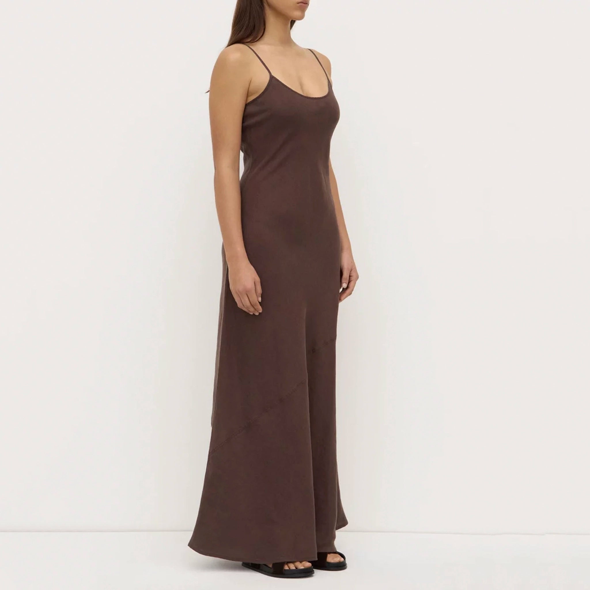 Woman wearing a brown slip dress against a white background