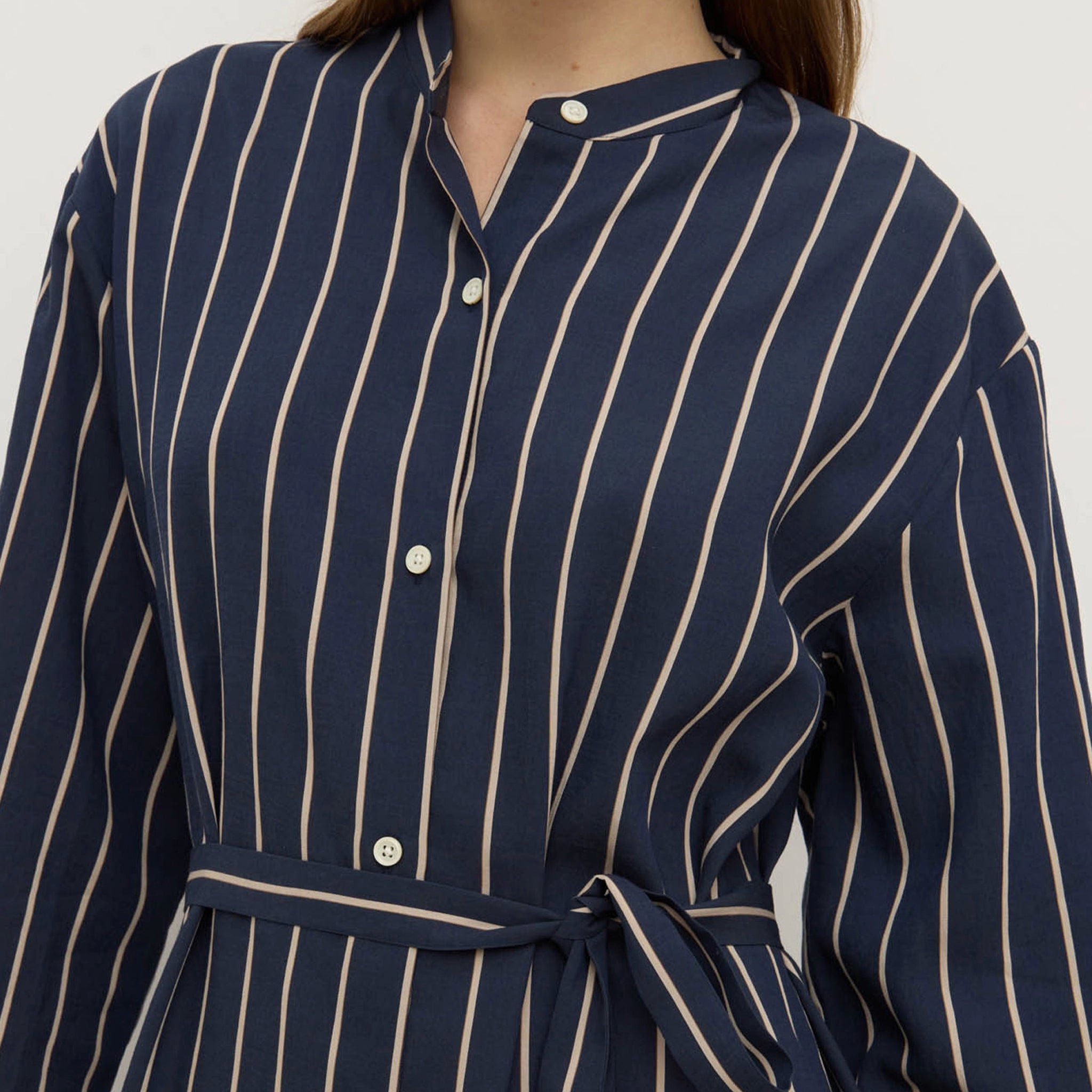Navy blue dress with white pinstripes on a plain background