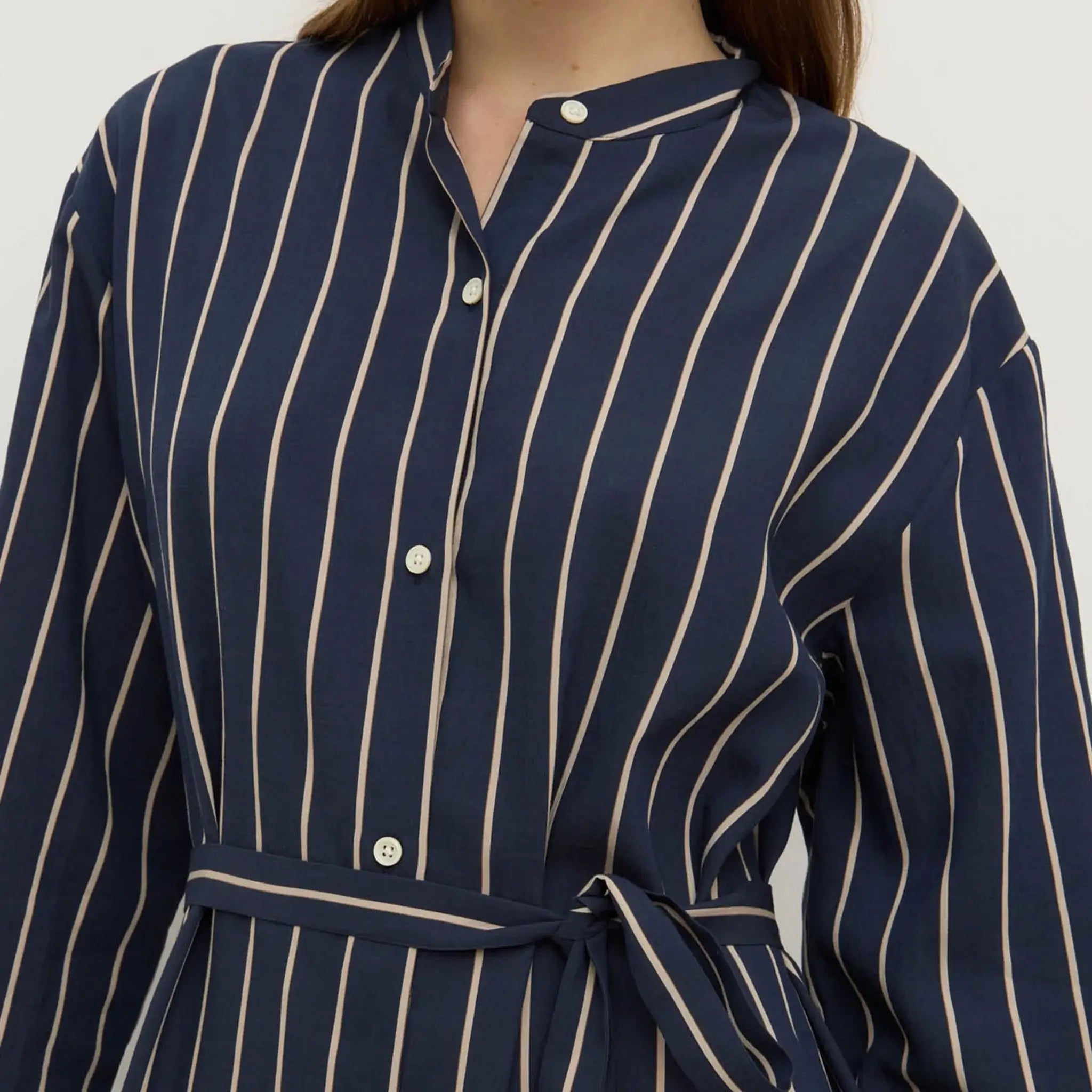 Navy blue dress with white pinstripes on a plain background