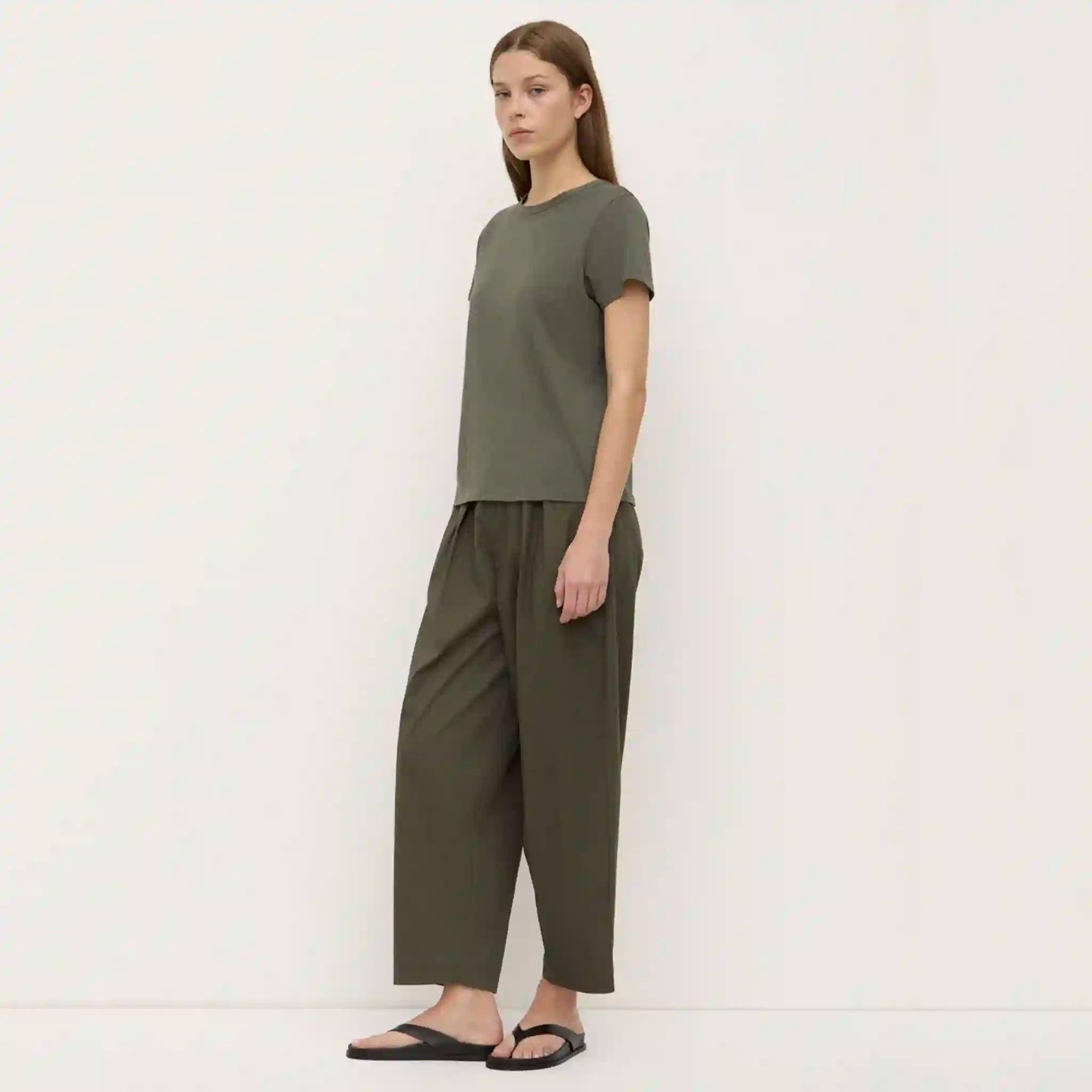 Woman wearing an olive green outfit against a white background