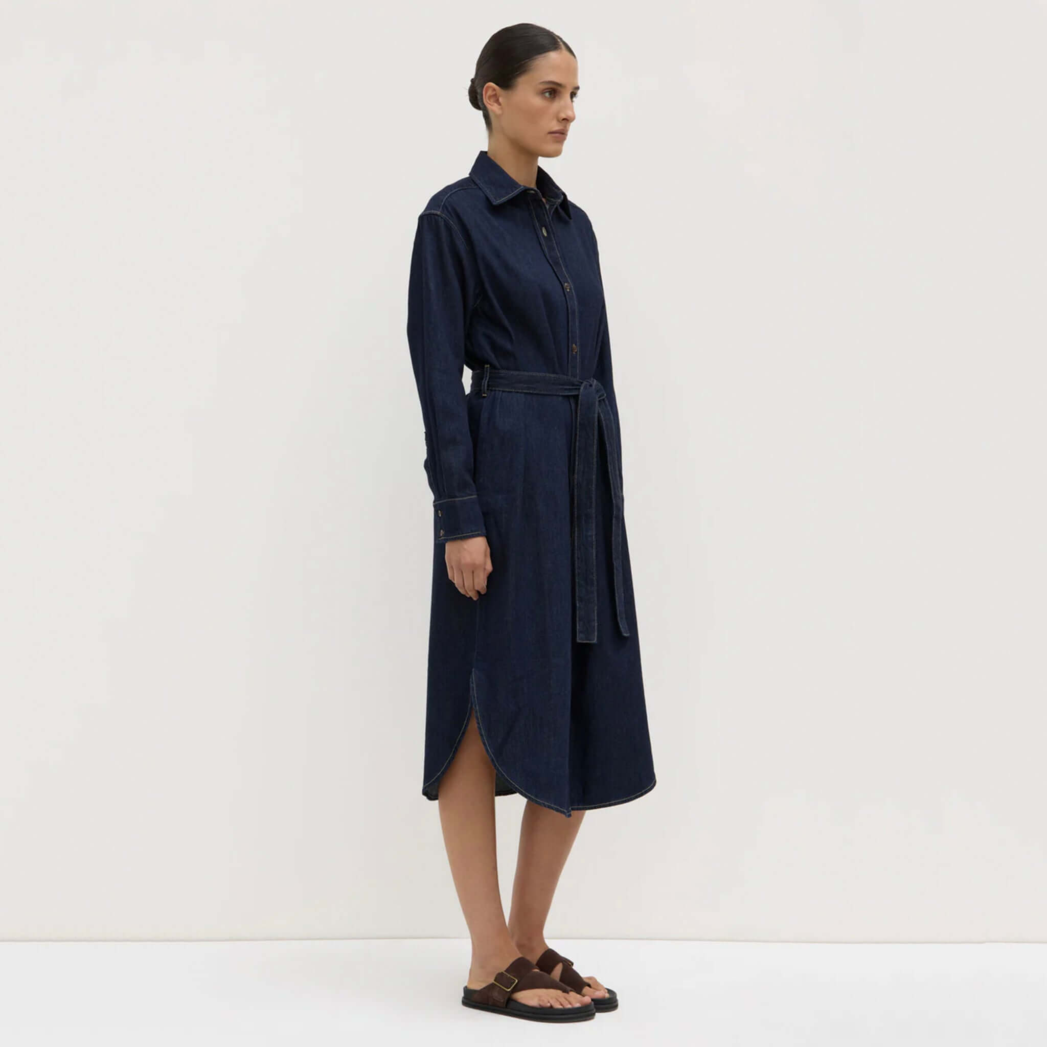 Woman wearing a navy blue dress against a white background