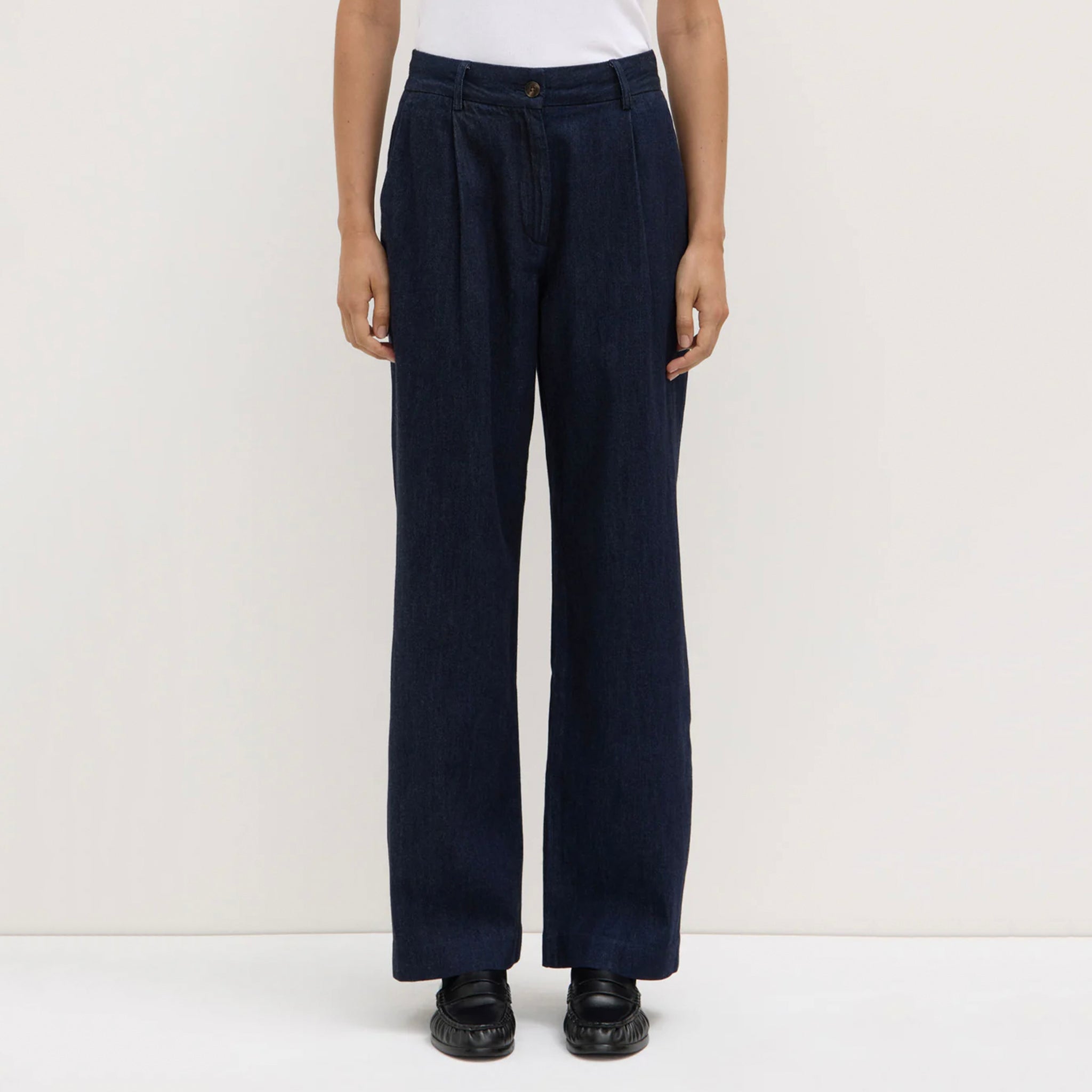 Person wearing navy wide-leg pants on a white background