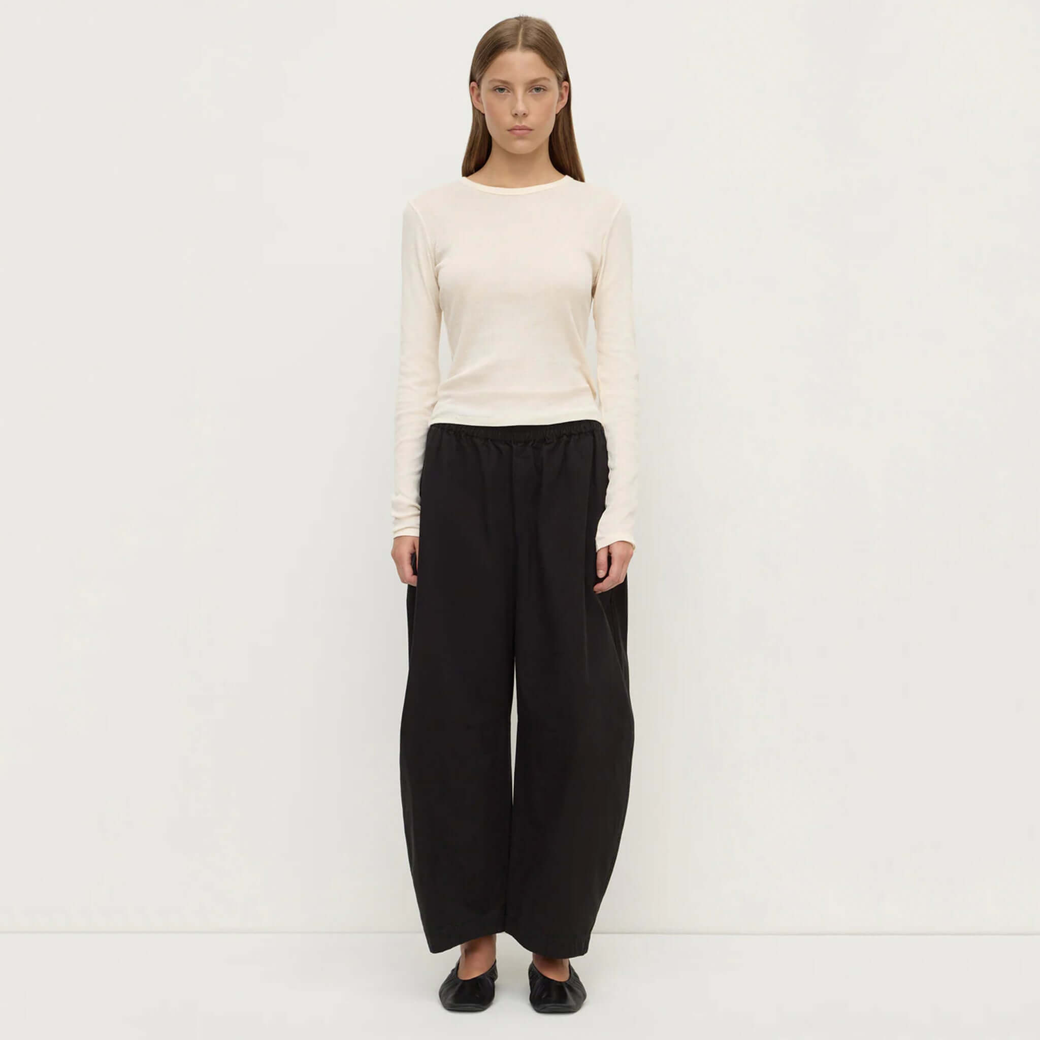 Model wearing Assembly Label Lola Barrel Pants - Black with a long-sleeve top, showcasing relaxed fit and stylish silhouette.