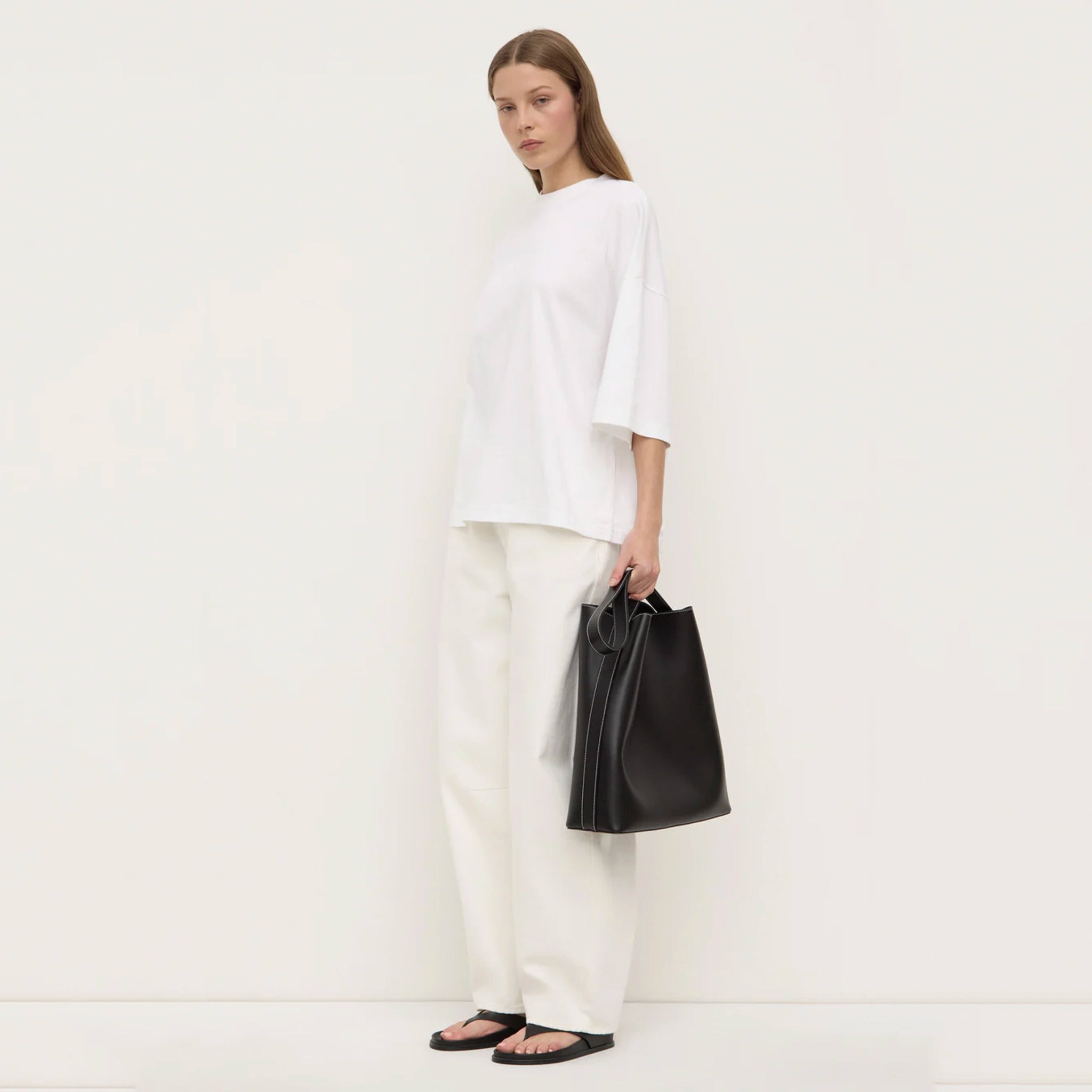 Woman holding a black bag against a white background