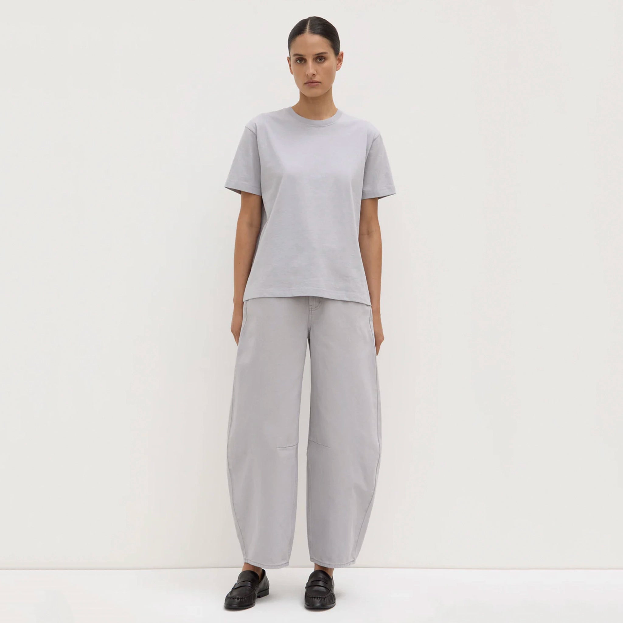 Person wearing a gray outfit on a white background