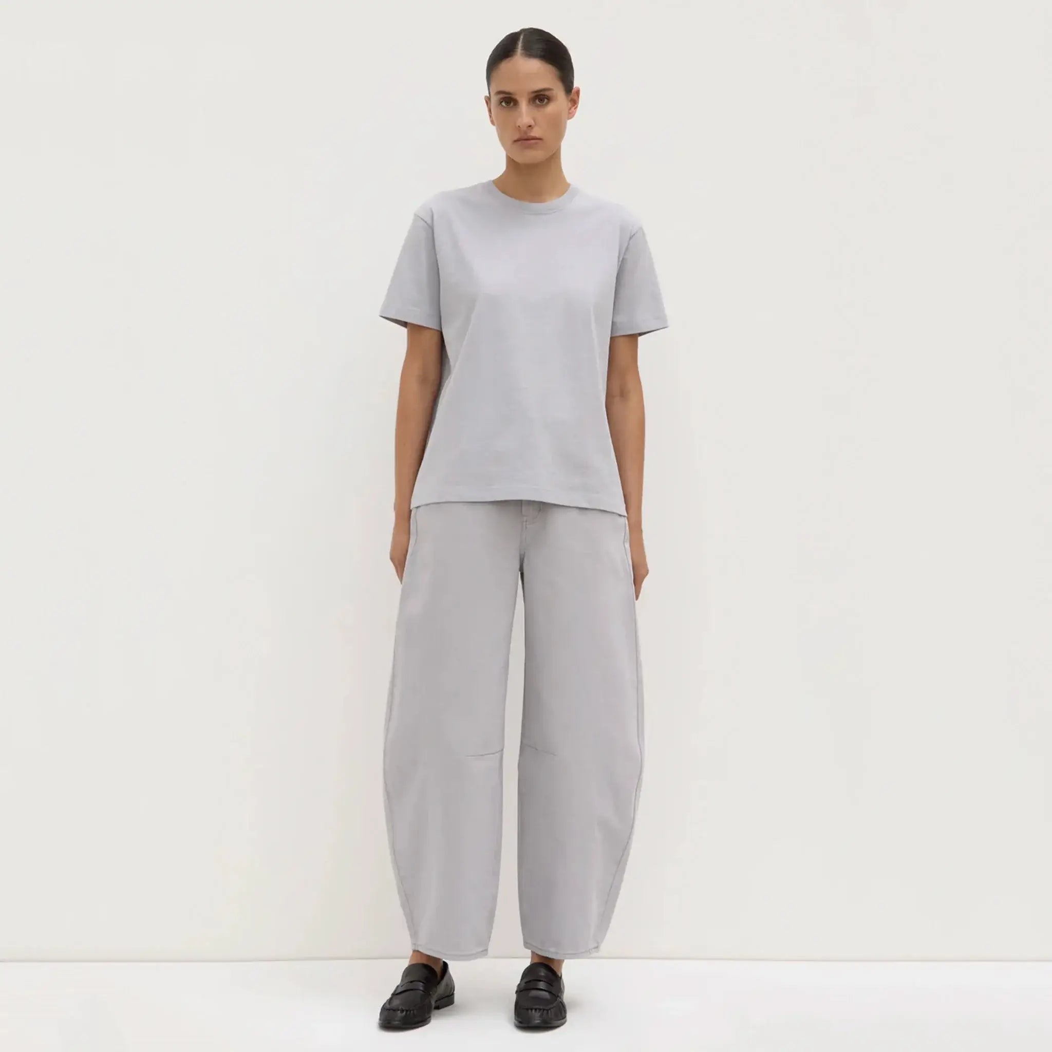 Person wearing a gray outfit on a white background