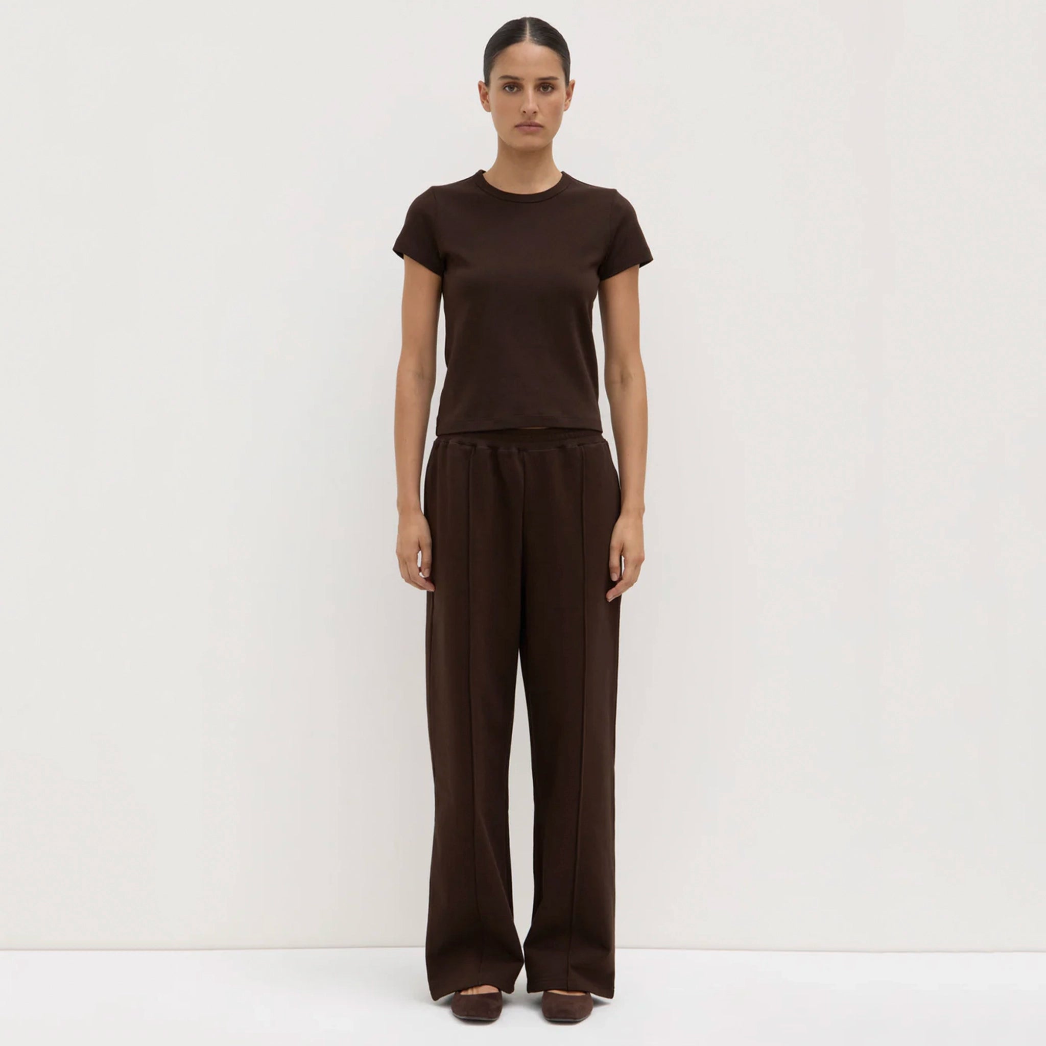 Woman wearing a brown outfit on a white background