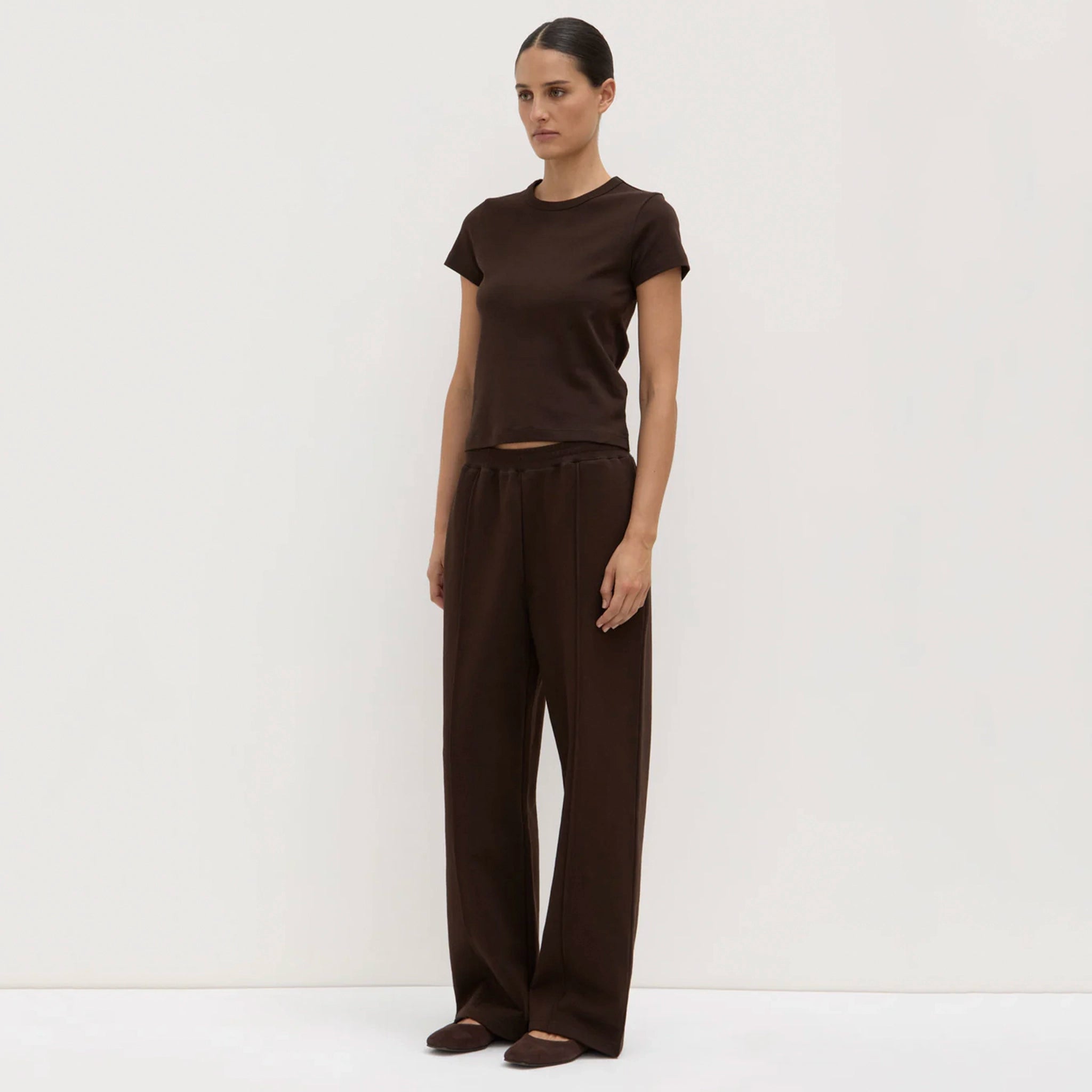 Woman wearing a brown outfit against a white background