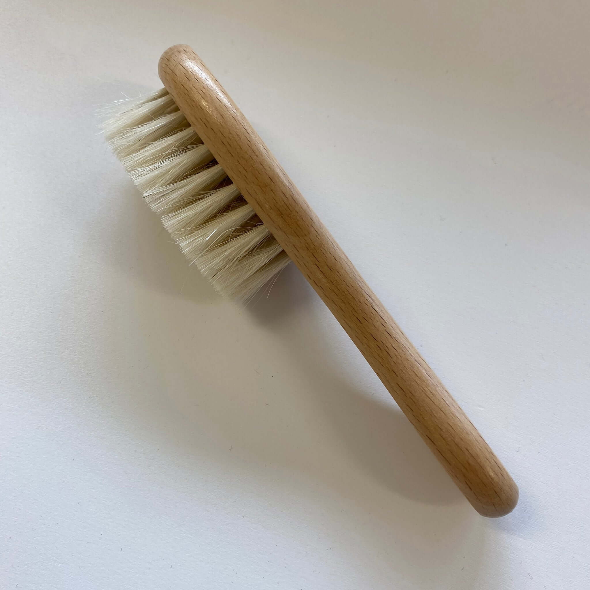 Baby Soft Hair Brush featuring a smooth wooden handle and ultra-soft goat-hair bristles for delicate newborns.