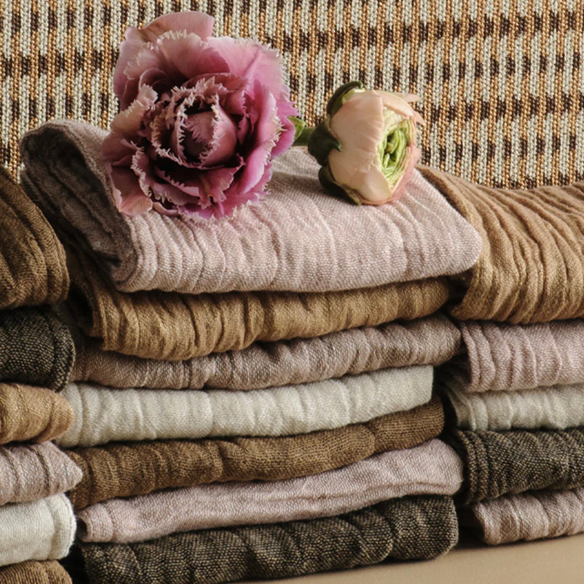 Stack of folded wash cloths with pink flowers on a textured surface