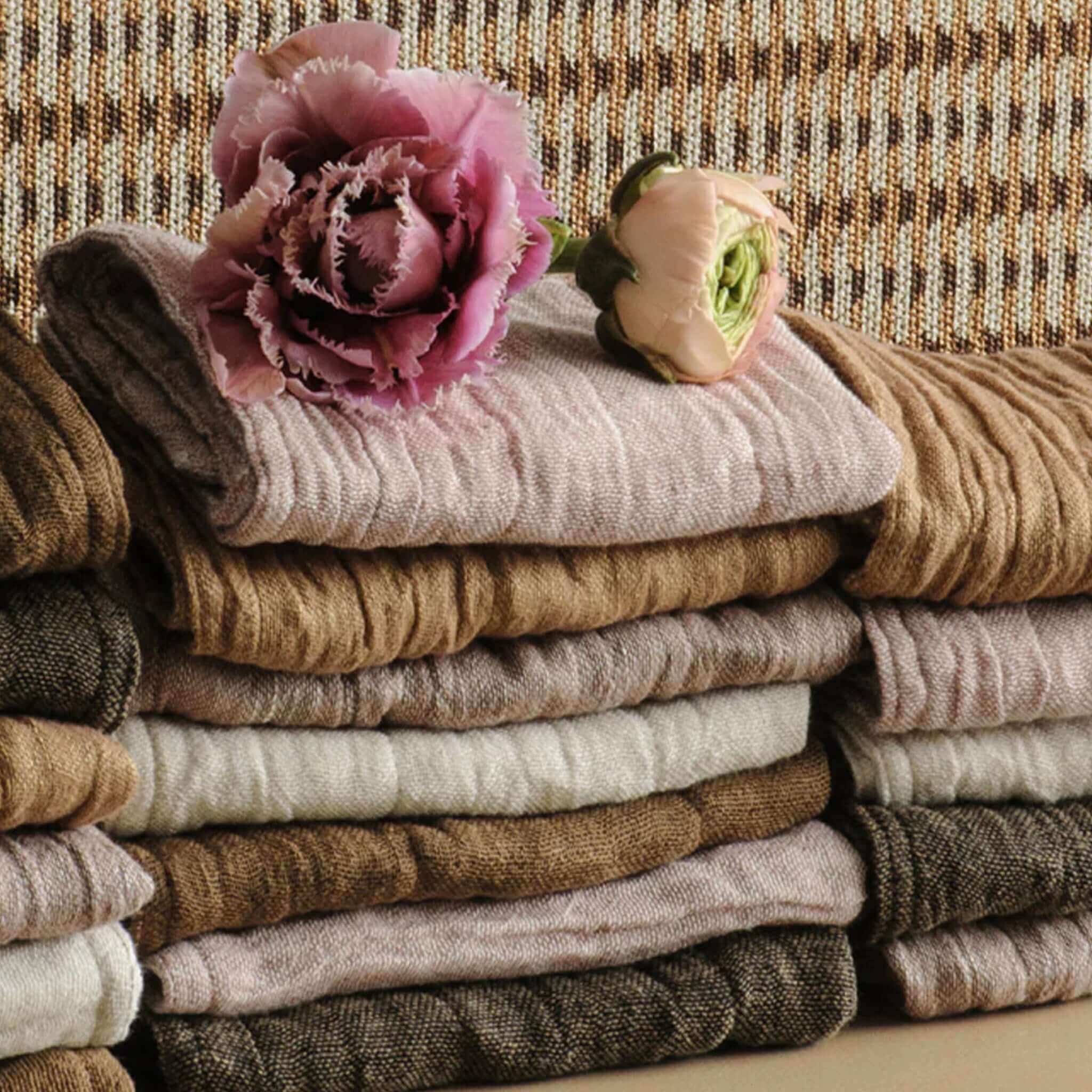 Stack of folded wash cloths with pink flowers on a textured surface