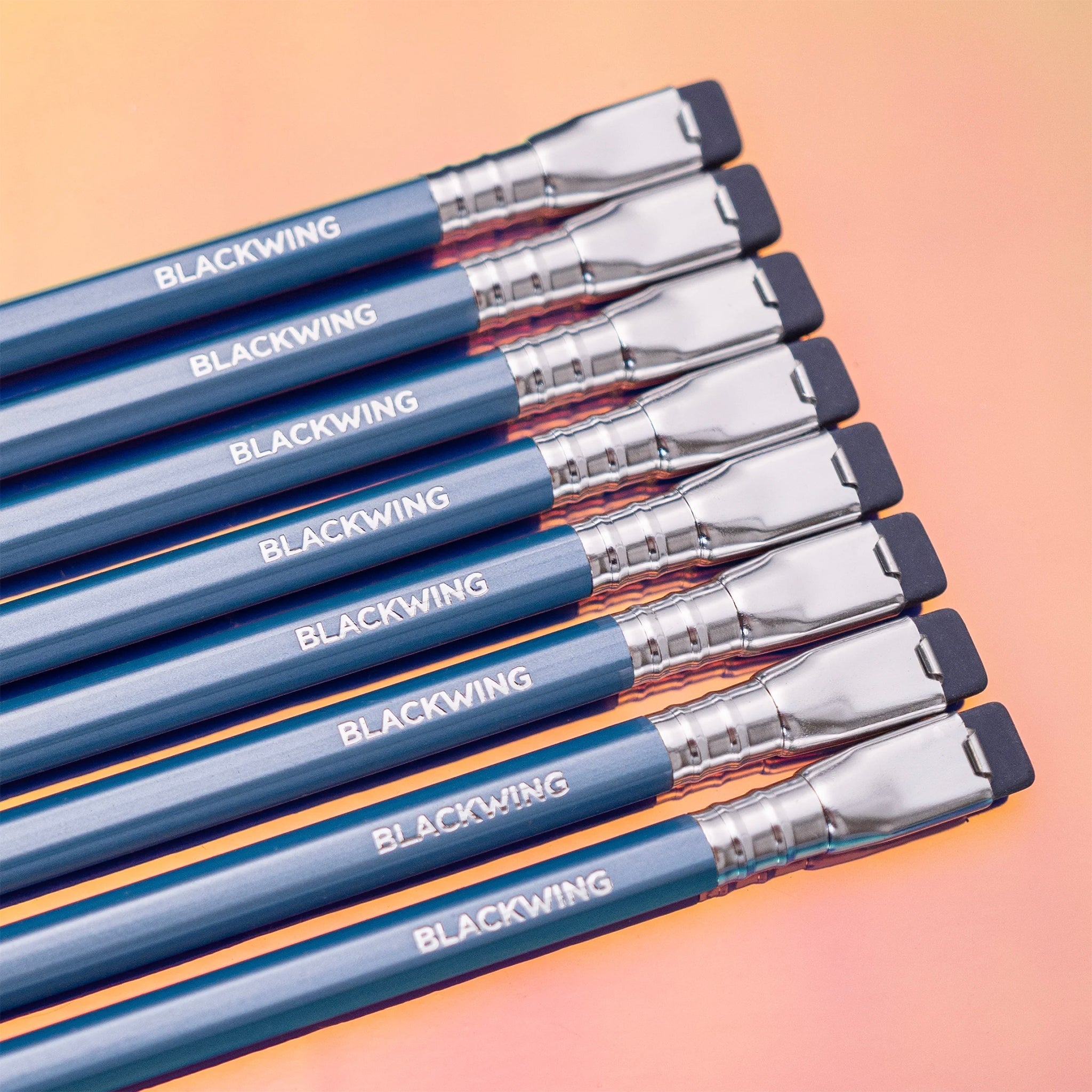Blackwing Blue Pearl Pencil set with blue lacquered barrels, silver ferrules, and black erasers on peach background