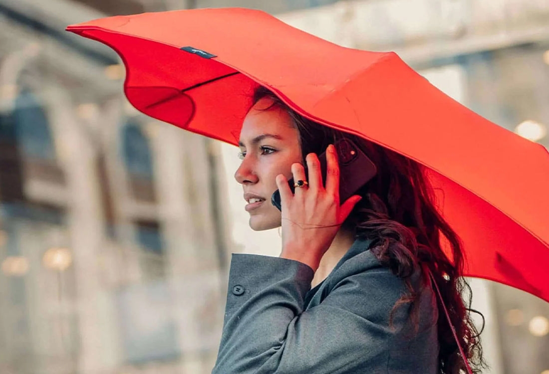 Woman holding a red umbrella in an urban setting