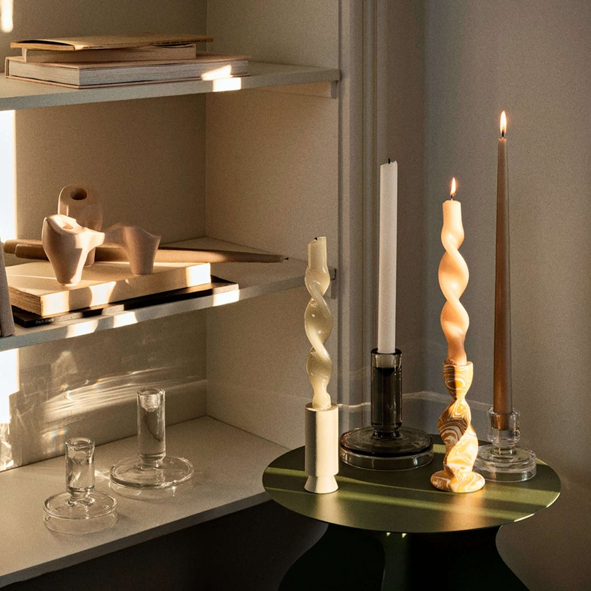 Broste Copenhagen Glass Petra Candleholder - Clear Small displayed with taper candles on a stylish shelf.