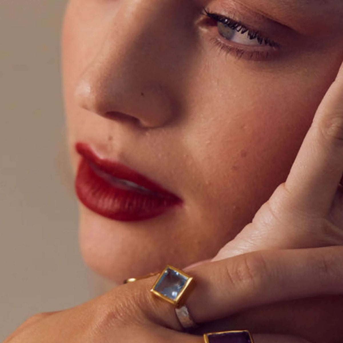 Cathy Pope Oracle Gold & Silver Ring - Blue Topaz worn on a hand with elegant makeup and red lipstick.