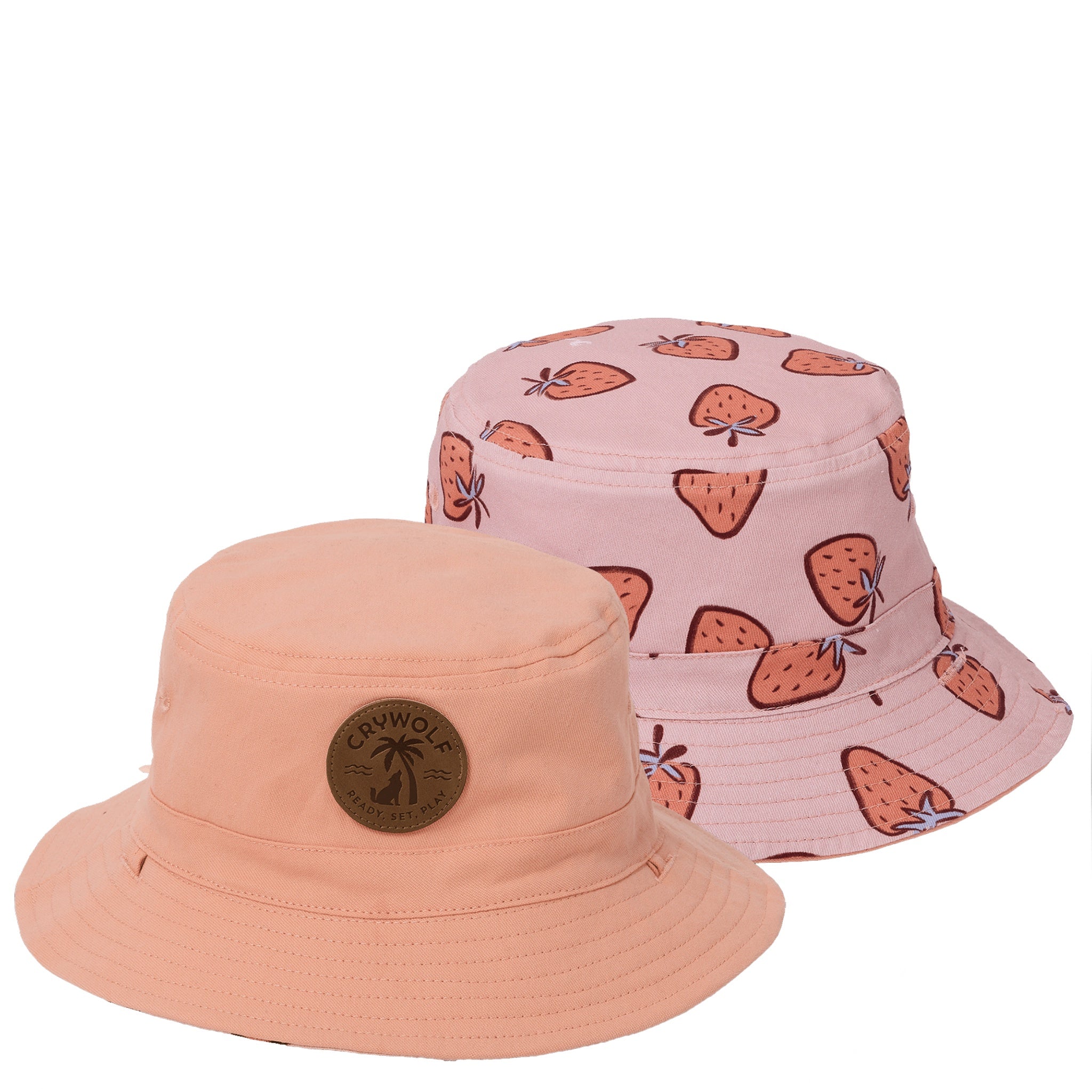 Two bucket hats, one peach and one pink with strawberry pattern, on a white background.