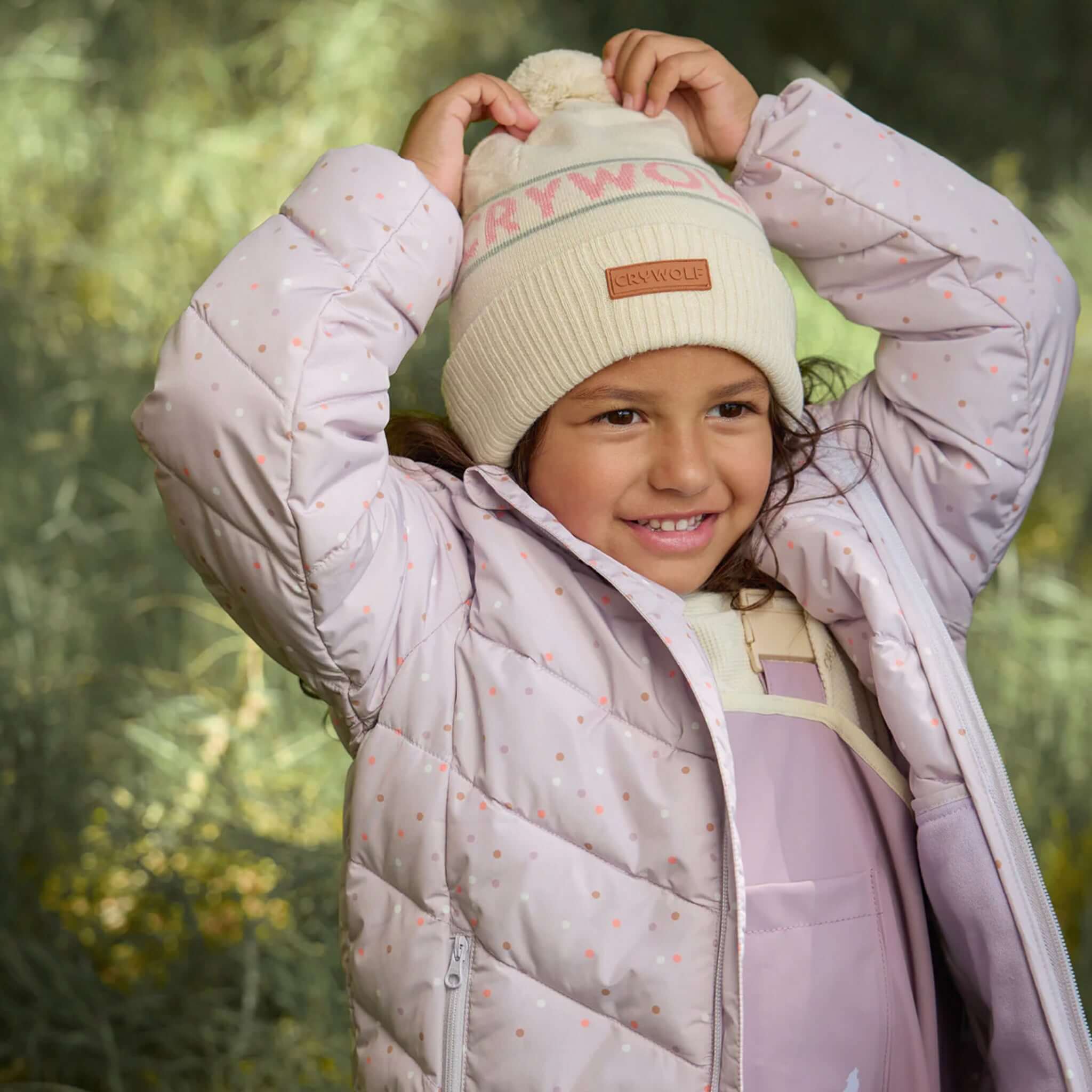 Alt Tag: Crywolf Alpine Beanie - Harvest on child, cream retro pom beanie in outdoor winter setting, soft Polylana comfort