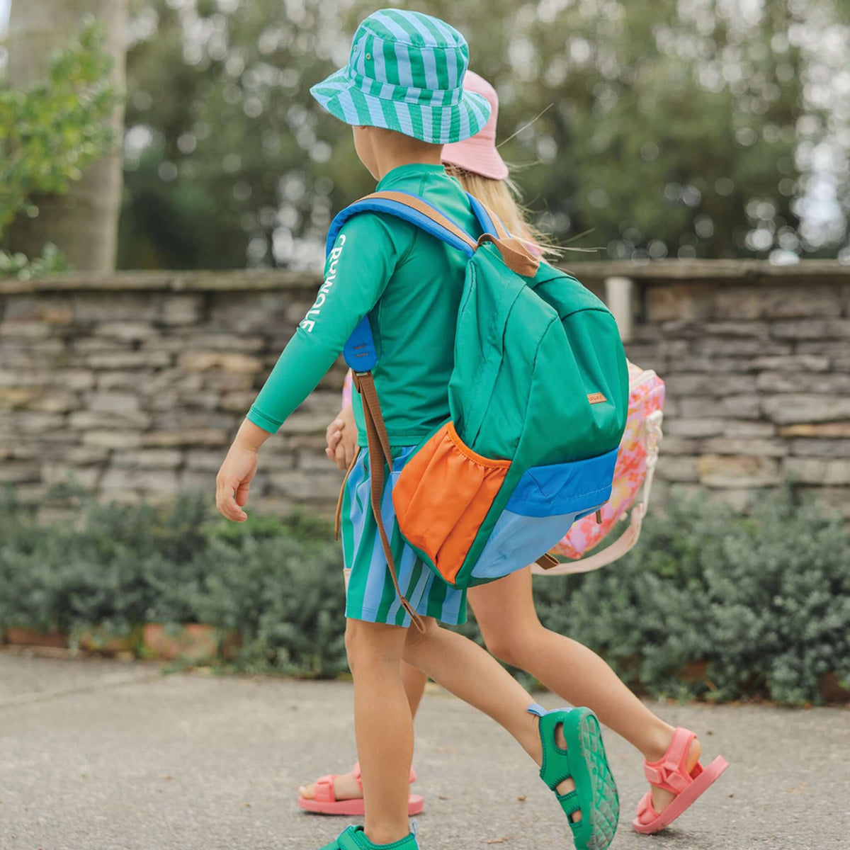 Children walking outdoors with Crywolf Daypack -Seaside Colourblock, showcasing its vibrant colours and design.