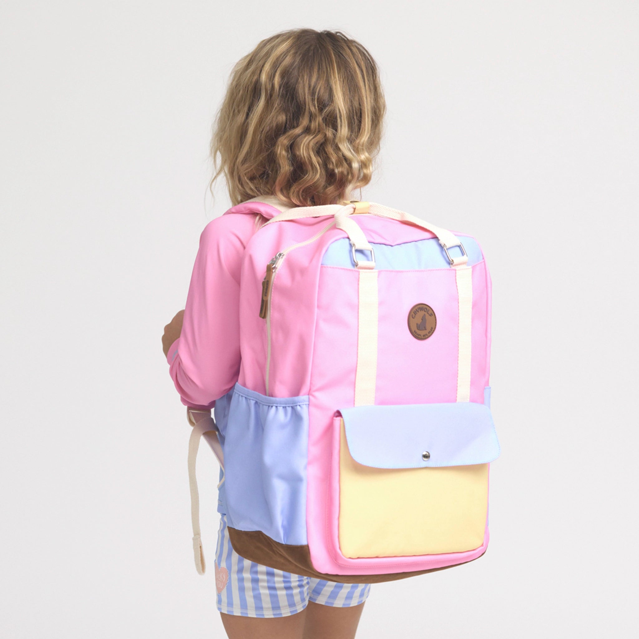 Person wearing a pastel-colored backpack on a plain background
