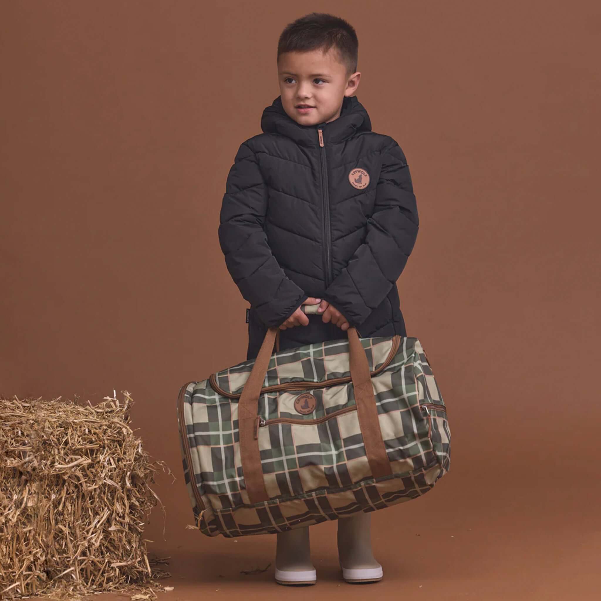 Alt Tag: Crywolf Packable Duffel Bag - Field Plaid carried by child, lightweight packable duffel with wide opening and compartments