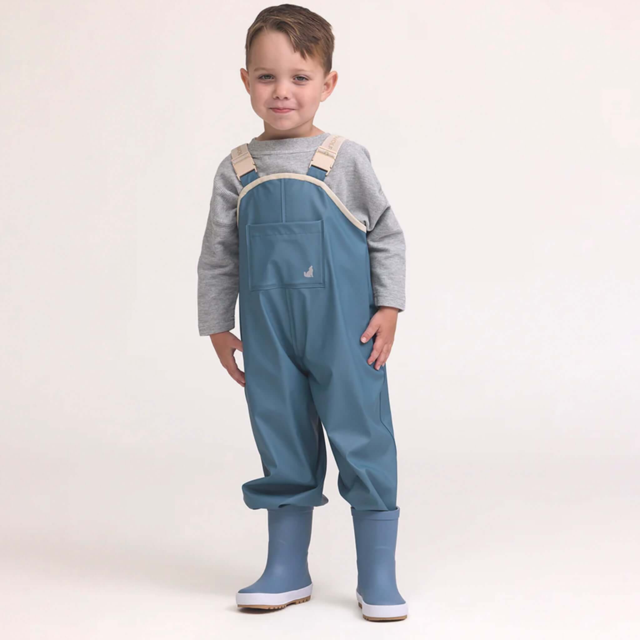 Crywolf Rain Overalls - Highland Blue on child model, fully waterproof adjustable rain bib overalls with boots for outdoor play