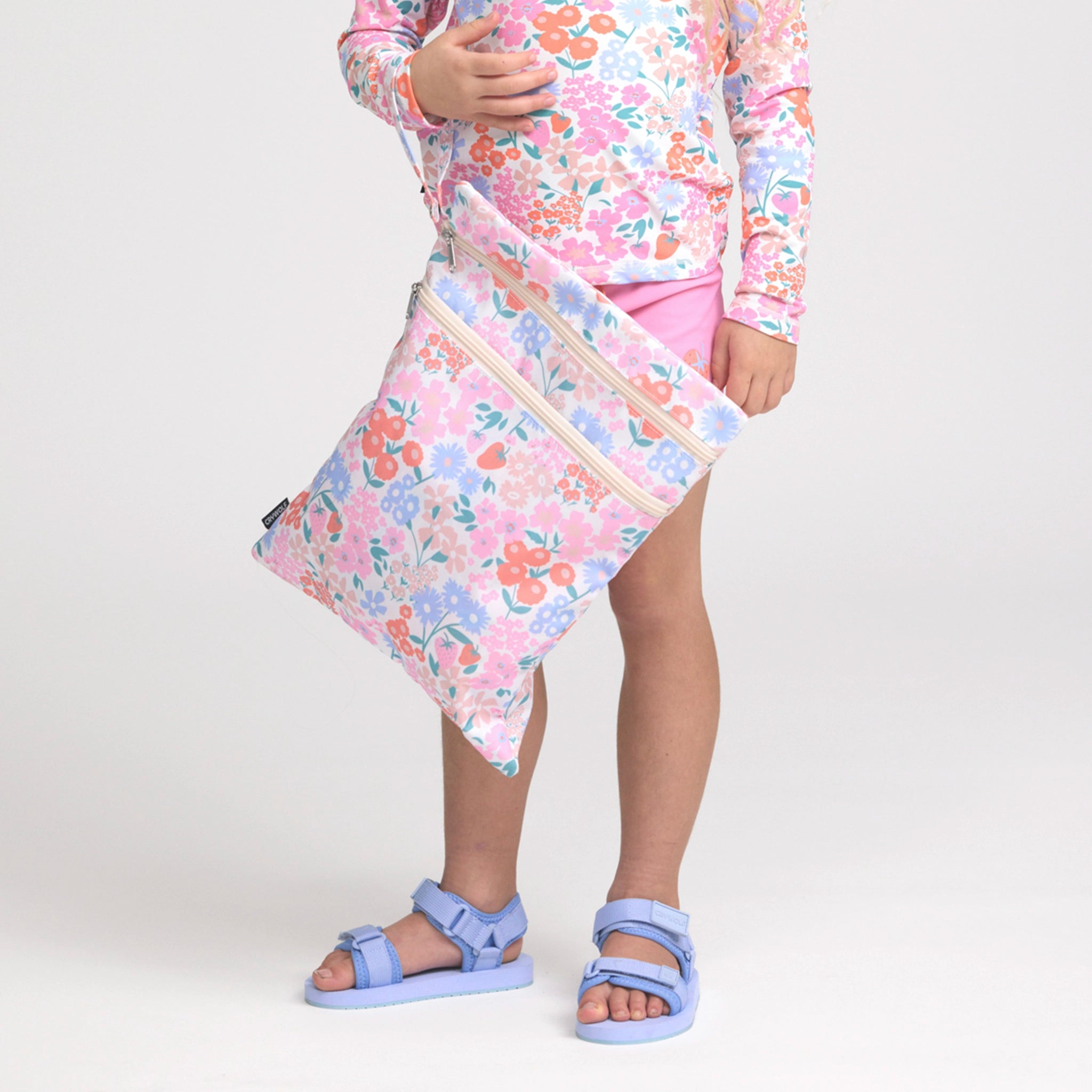 Girl holding a floral swim bag.