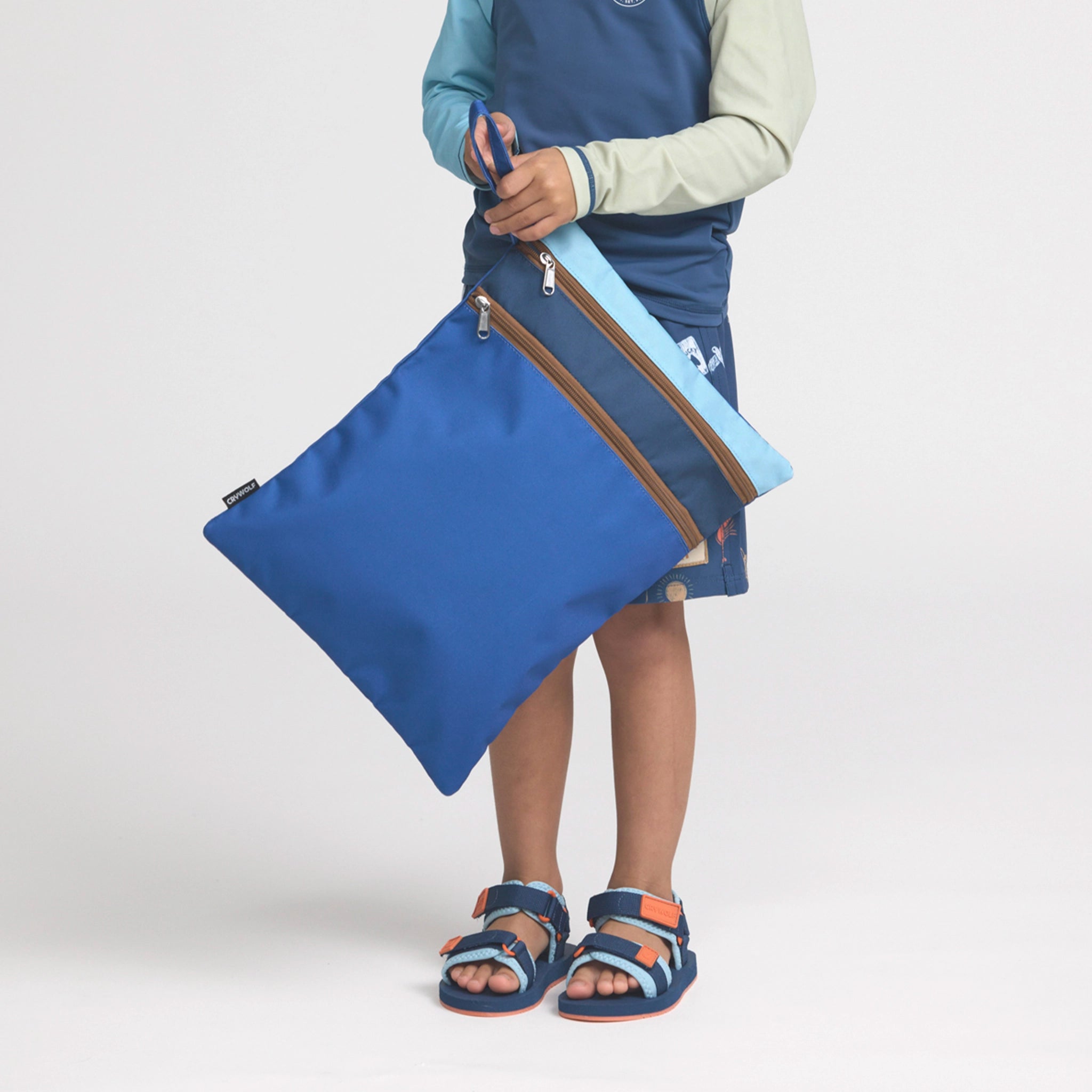 Boy holding a multicolored swim bag.